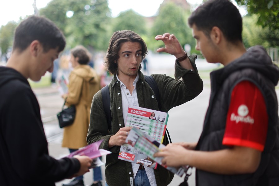 A supporter of the leftist coalition Nouveau Front Populaire (New Popular Front) campaigns for the second round of the legislative election, Thursday, July 4, 2024 in Strasbourg, eastern France. French President Emmanuel Macron called the surprise legislative election on June 9 after his centrist alliance suffered a punishing defeat at the hands of the National Rally in French voting for the European Parliament. (AP Photo/Jean-Francois Badias)