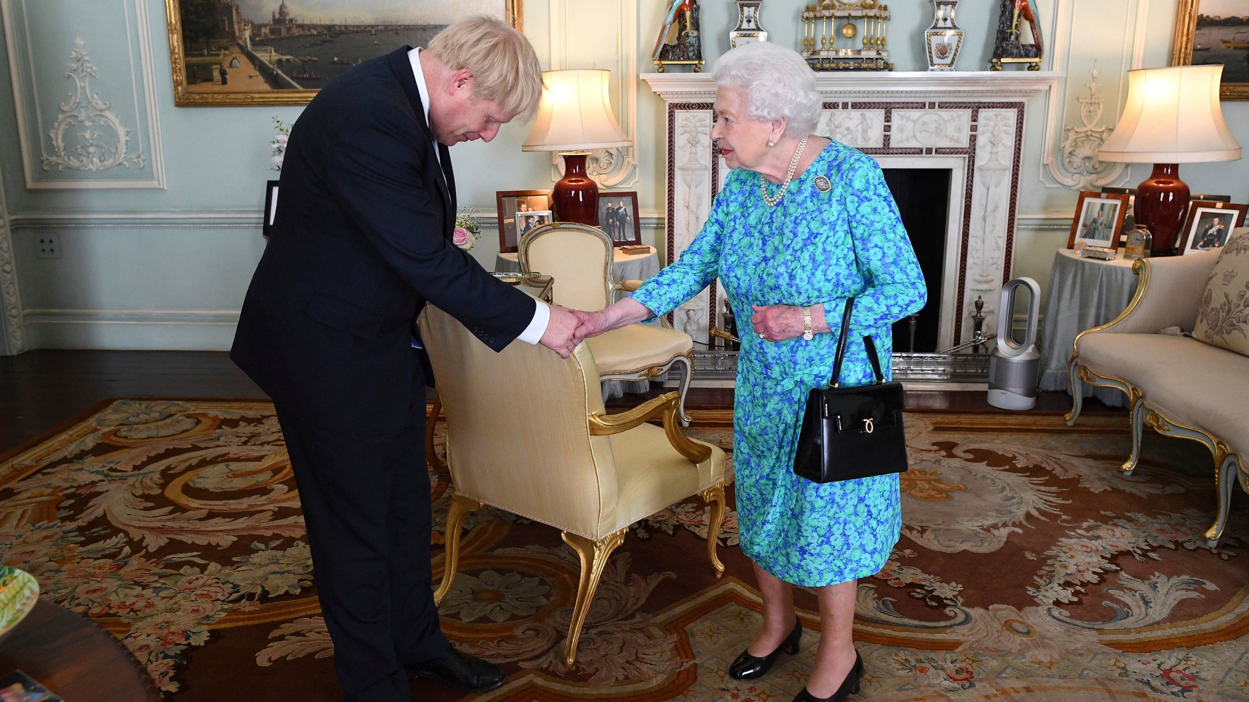 FILE - Britain's Queen Elizabeth II welcomes newly elected leader of the Conservative party Boris Johnson during an audience at Buckingham Palace, London, on July 24, 2019, where she invited him to become prime minister and form a new government. (Victoria Jones/Pool via AP, File)