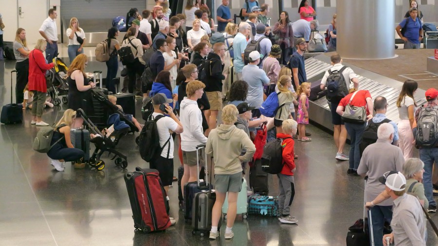 Holiday travelers wait for their luggage after arriving at Salt Lake City International Airport Wednesday, July 3, 2024, in Salt Lake City. (AP Photo/Rick Bowmer)