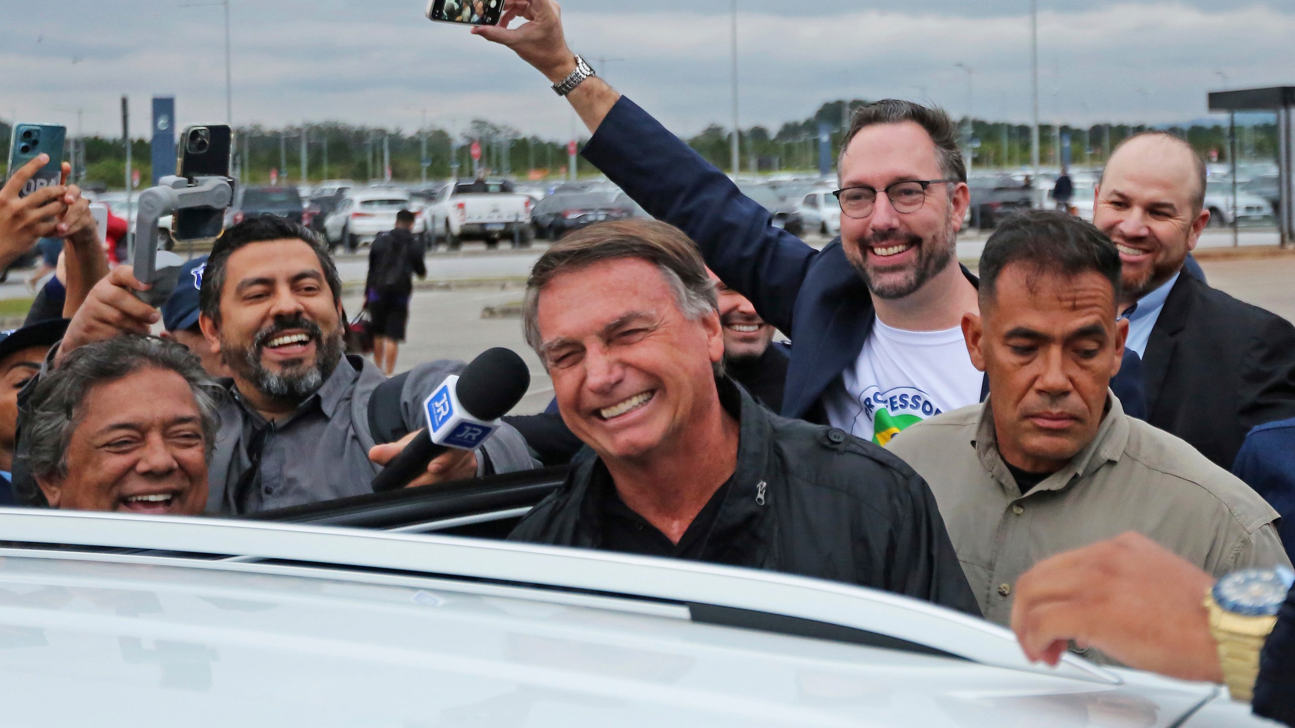 Former Brazilian President Jair Bolsonaro smiles as he prepares to depart the international airport in Florianopolis, Santa Catarina state, Brazil, Friday, July 5, 2024. Brazilian police have indicted Bolsonaro for money laundering and criminal association in connection with undeclared diamonds the far-right leader received from Saudi Arabia during his time in office, according to a source with knowledge of the accusations. (AP Photo/Heuler Andrey)