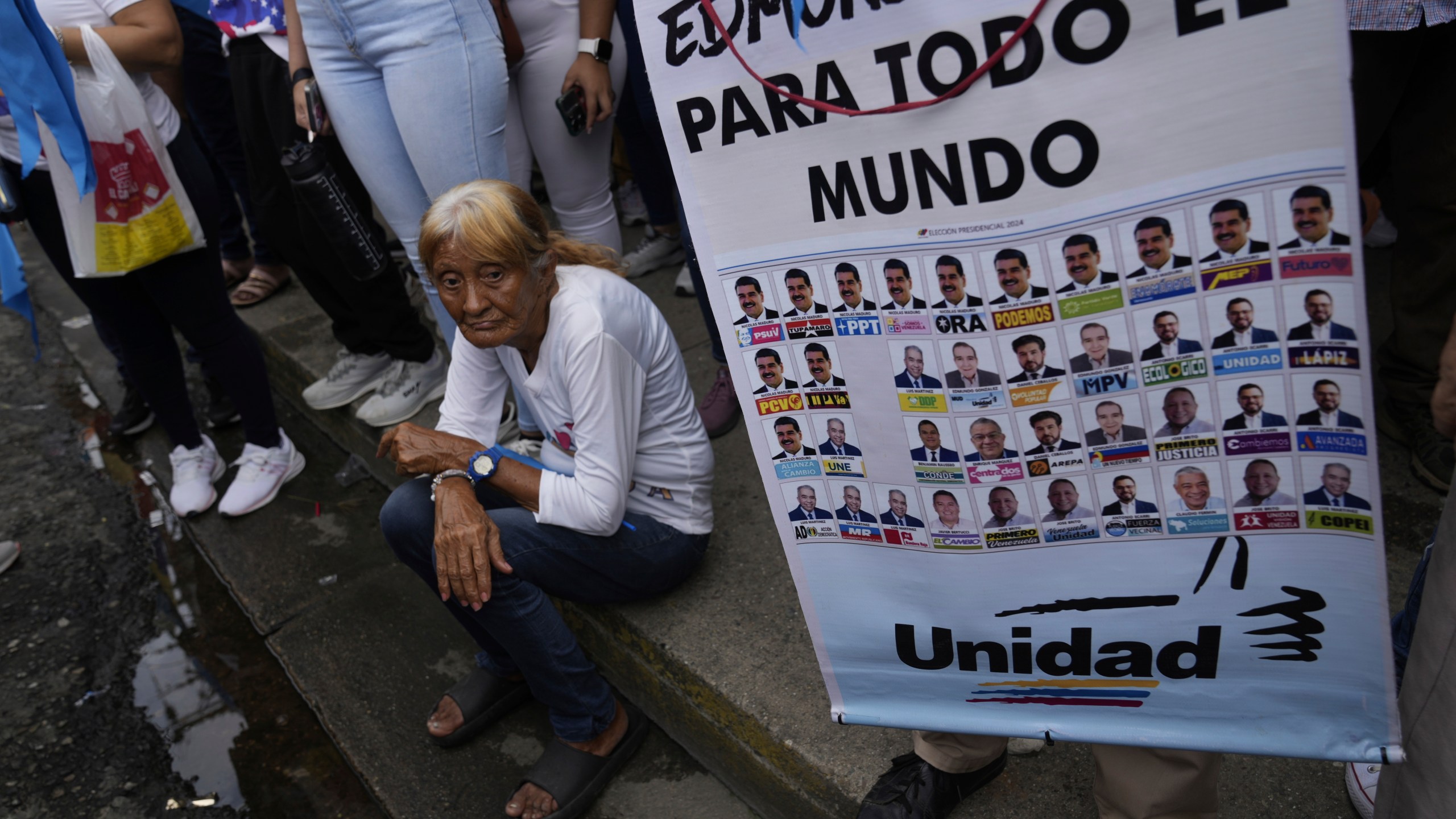 A supporter of opposition presidential candidate Edmundo Gonzalez holds a poster featuring the presidential ballot as thousands wait for his arrival at a campaign rally in Barinas, Venezuela, Saturday, July 6, 2024. The official campaign period for the July 28 election kicked off on July 4. (AP Photo/Ariana Cubillos)