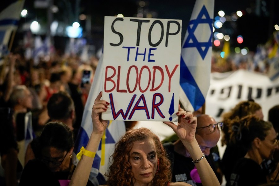 A demonstrator holds a sign during a protest marking nine months since the start of the war and calling for the release of hostages held in the Gaza Strip by the Hamas militant group, in Tel Aviv, Israel, Sunday, July 7, 2024. (AP Photo/Leo Correa)