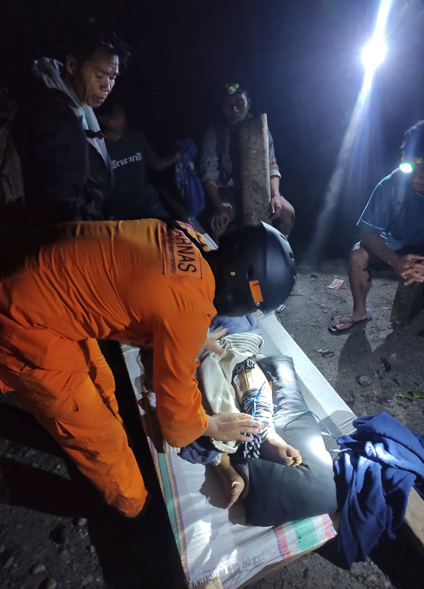 In this photo released by the Indonesian National Search and Rescue Agency (BASARNAS), an injured victim of a landslide is attended to in Suwawa on Sulawesi Island, Indonesia, early Monday, July 8, 2024. The landslide triggered by torrential rains crashed onto an unauthorized gold mining operation on Indonesia's Sulawesi island, killing a number of miners, officials said Monday. (BASARNAS via AP)