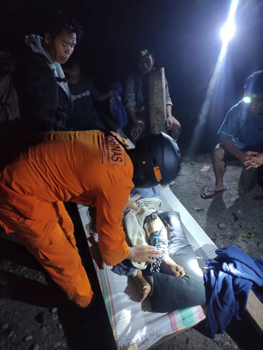 In this photo released by the Indonesian National Search and Rescue Agency (BASARNAS), an injured victim of a landslide is attended to in Suwawa on Sulawesi Island, Indonesia, early Monday, July 8, 2024. The landslide triggered by torrential rains crashed onto an unauthorized gold mining operation on Indonesia's Sulawesi island, killing a number of miners, officials said Monday. (BASARNAS via AP)