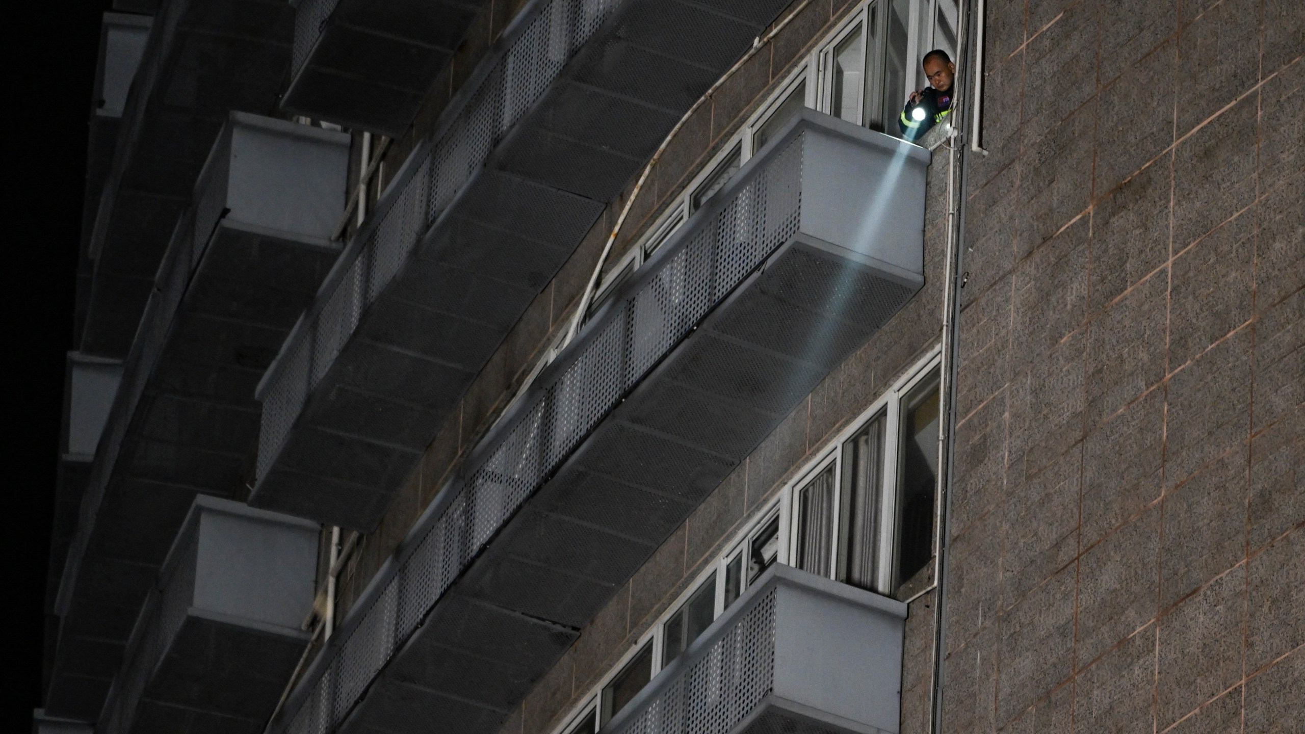 In this photo released by Xinhua News Agency, a firefighter checks Thursday, July 18, 2024, in the aftermath of Wednesday's deadly fire at the department store in Zigong City, southwest China's Sichuan Province. (Wang Xi/Xinhua via AP)