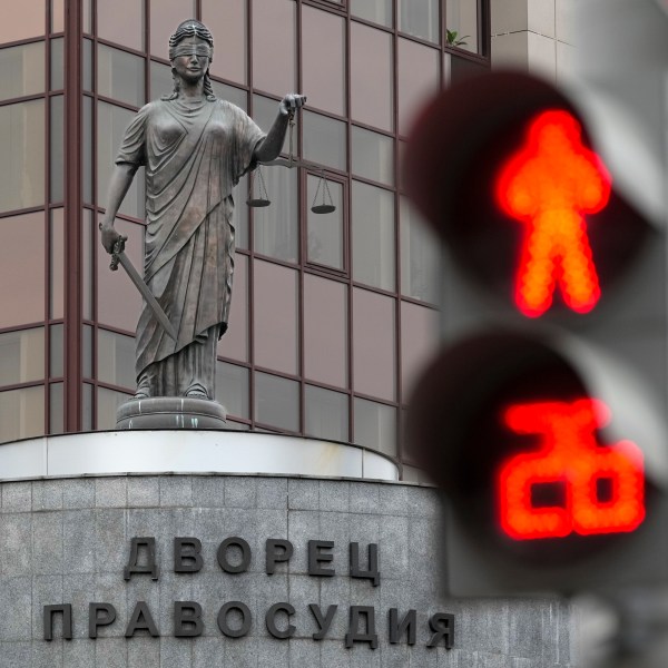 The Lady Justice statue is seen through a traffic light atop of the court building with the words reading, "Palace of justice," on the front in Yekaterinburg, Russia Friday, July 19, 2024, ahead of the trial of Wall Street Journal reporter Evan Gershkovich's suspected spying activities. Photo/Dmitri Lovetsky)