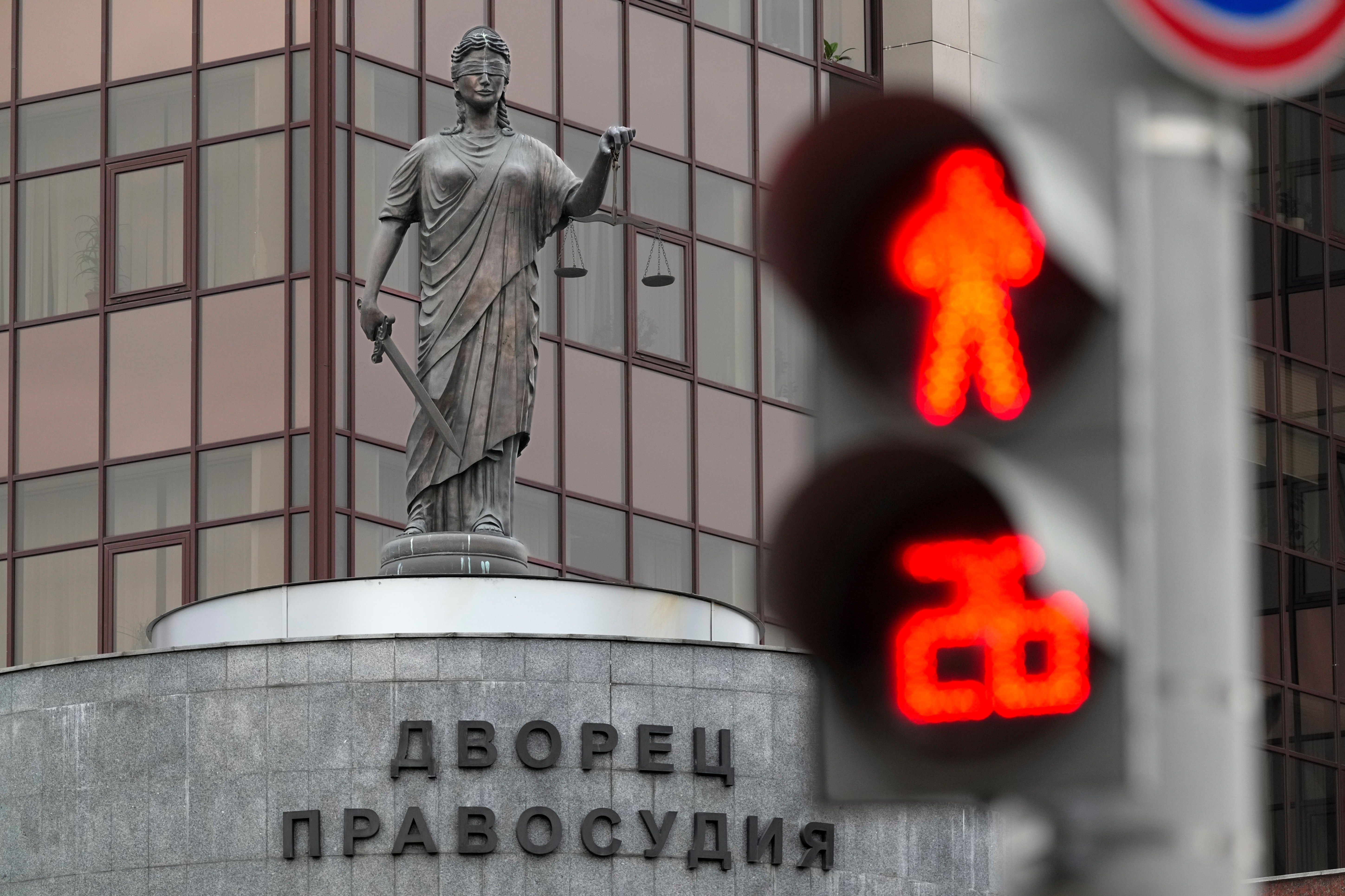 The Lady Justice statue is seen through a traffic light atop of the court building with the words reading, "Palace of justice," on the front in Yekaterinburg, Russia Friday, July 19, 2024, ahead of the trial of Wall Street Journal reporter Evan Gershkovich's suspected spying activities. Photo/Dmitri Lovetsky)