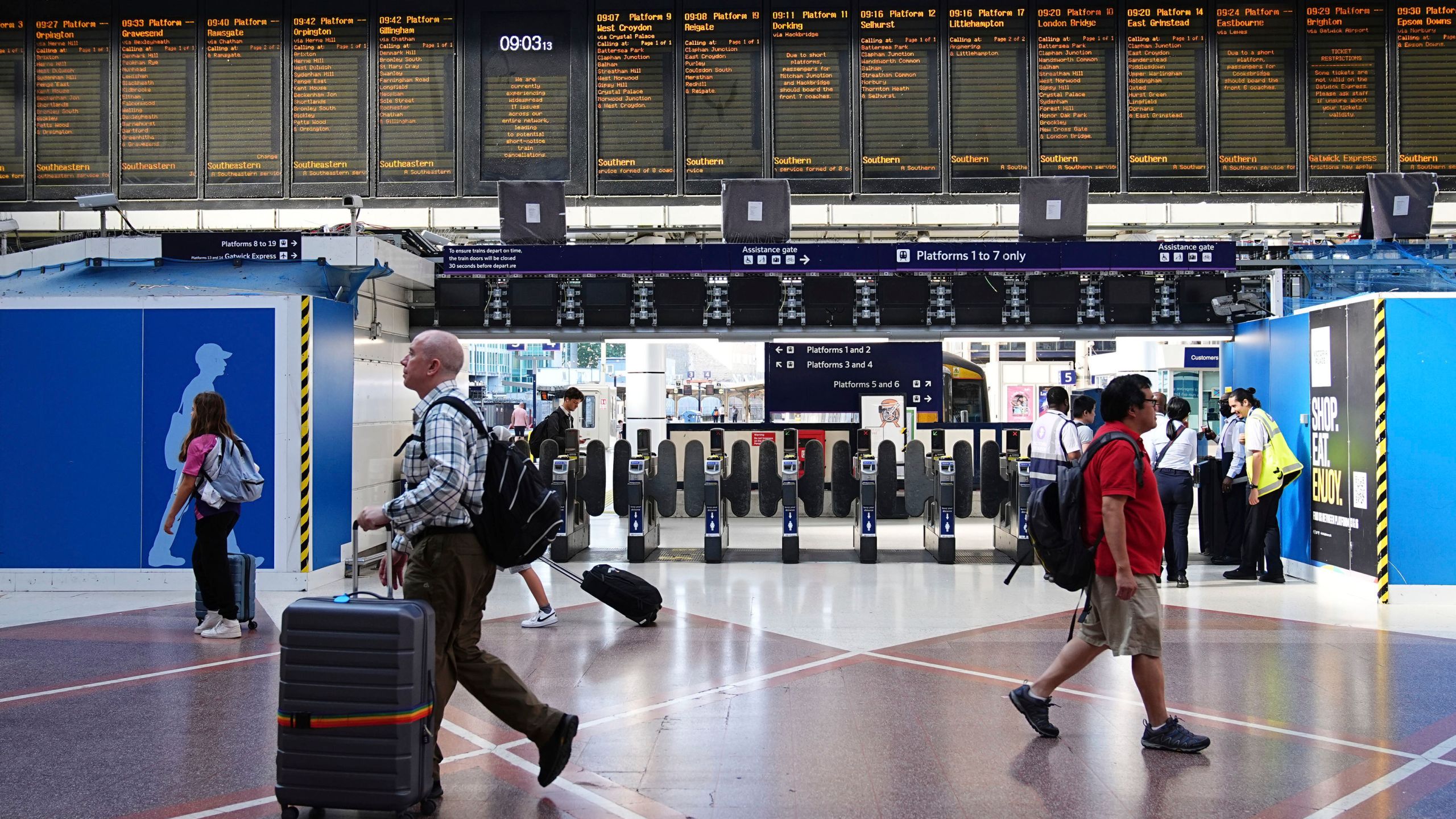 Passengers walk at Victoria train station, in London, amid reports of widespread IT outages affecting airlines, broadcasters and banks, Friday July 19, 2024. (Aaron Chown/PA via AP)