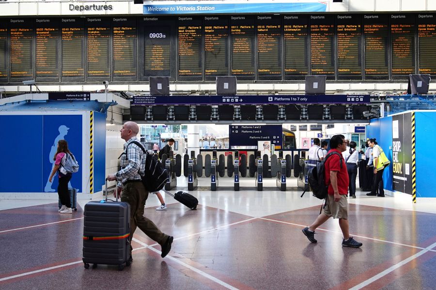 Passengers walk at Victoria train station, in London, amid reports of widespread IT outages affecting airlines, broadcasters and banks, Friday July 19, 2024. (Aaron Chown/PA via AP)