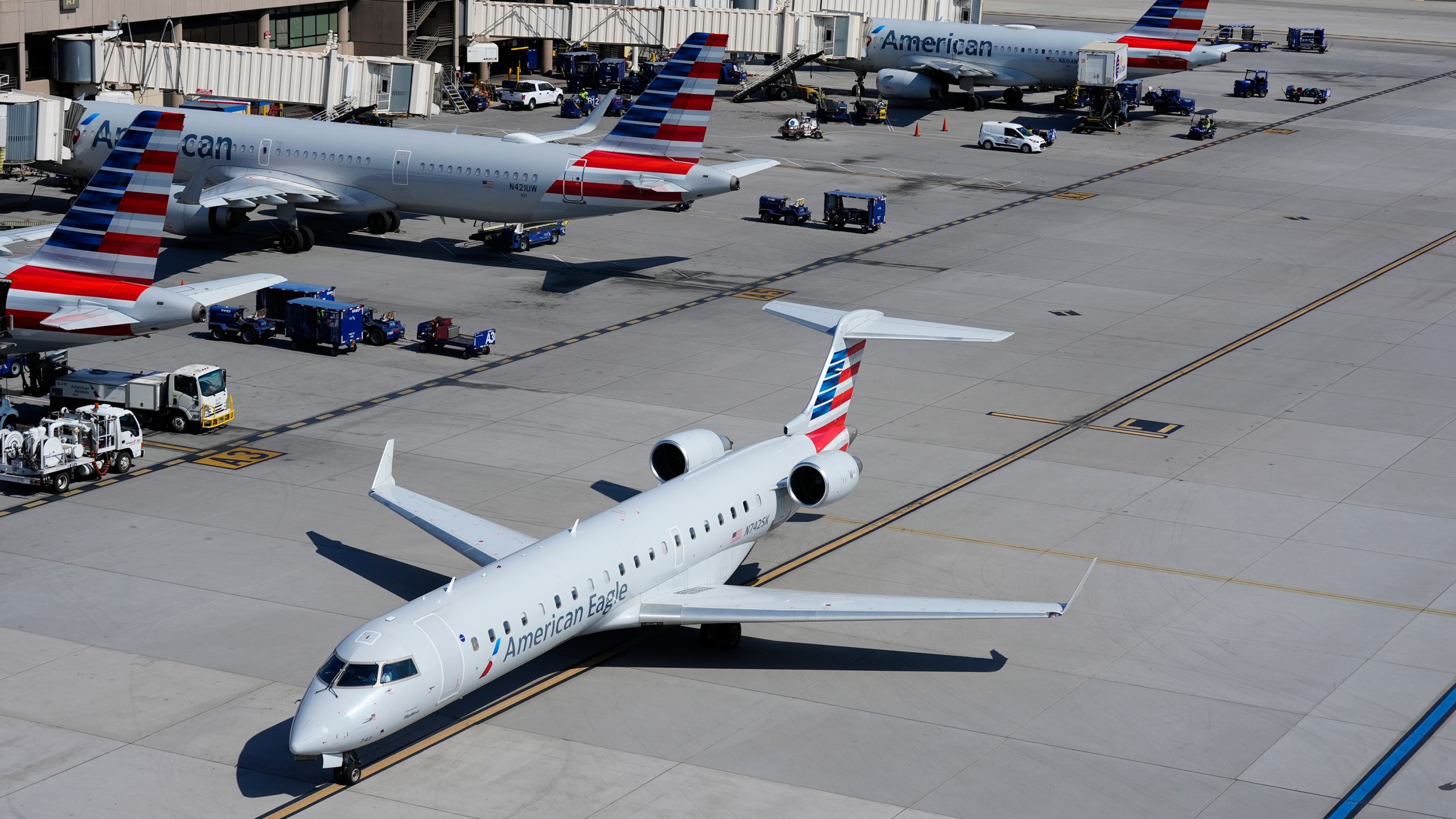 FILE - American Airlines planes wait at gates at Phoenix Sky Harbor International Airport Friday, July 19, 2024, in Phoenix. American Airlines and the union representing its flight attendants said they have reached agreement on a new contract Friday. (AP Photo/Ross D. Franklin, File)