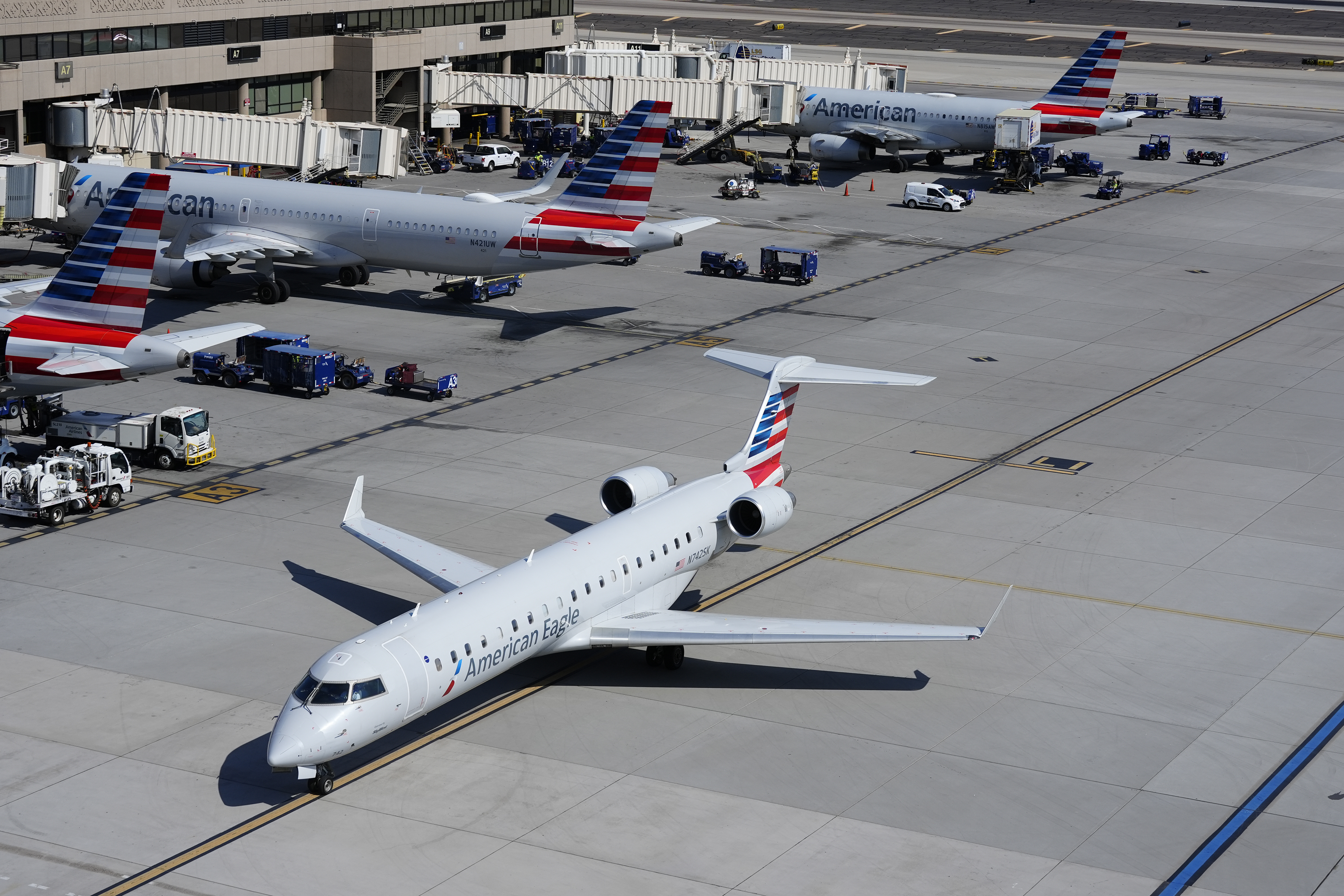 FILE - American Airlines planes wait at gates at Phoenix Sky Harbor International Airport Friday, July 19, 2024, in Phoenix. American Airlines and the union representing its flight attendants said they have reached agreement on a new contract Friday. (AP Photo/Ross D. Franklin, File)