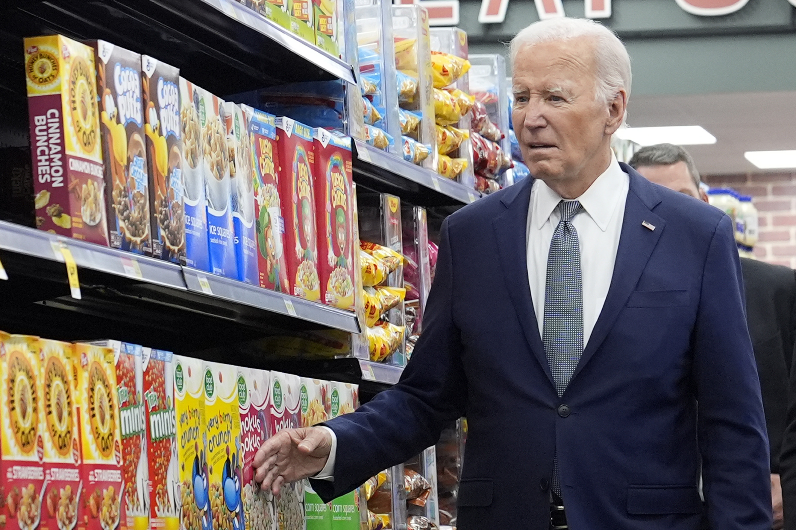 President Joe Biden walks past boxes of cereal in an aisle as he visits Mario's Westside Market in Las Vegas, Tuesday, July 16, 2024. (AP Photo/Susan Walsh)