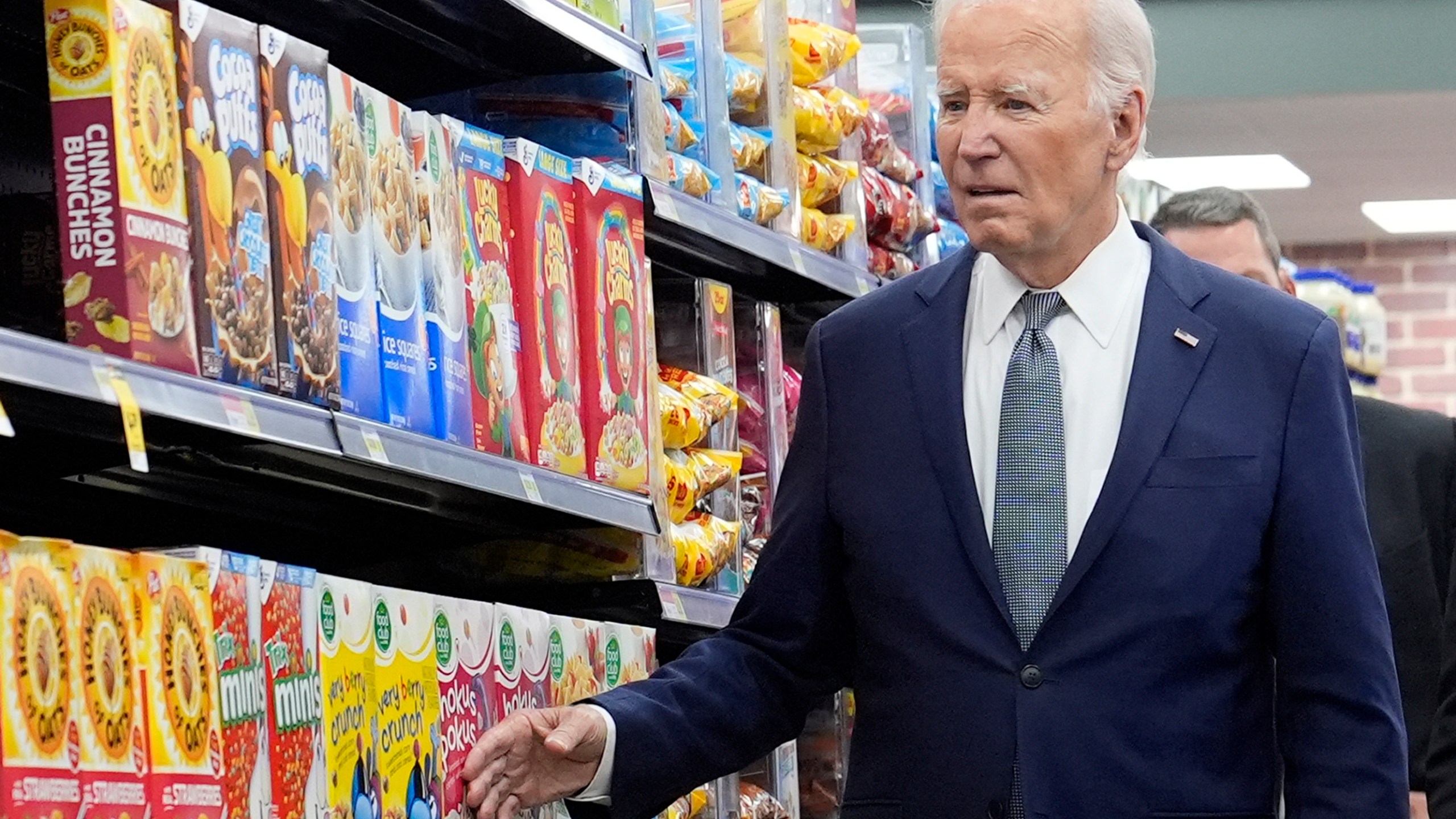 President Joe Biden walks past boxes of cereal in an aisle as he visits Mario's Westside Market in Las Vegas, Tuesday, July 16, 2024. (AP Photo/Susan Walsh)