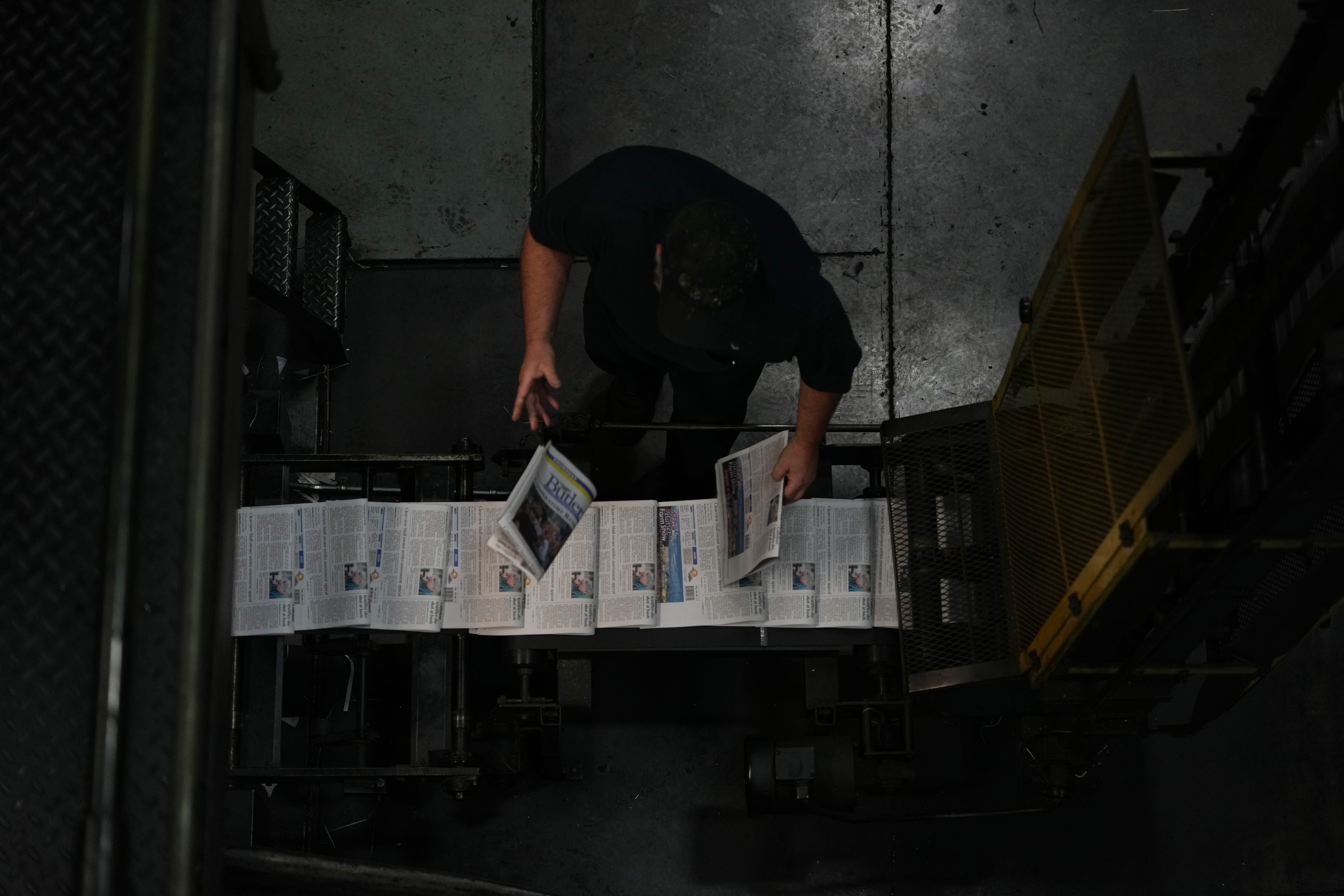 Kurt Slater, pressman at the Butler Eagle newspaper, pulls papers as they come off the press, Thursday, July 18, 2024, in Butler, Pa. (AP Photo/Matt Slocum)