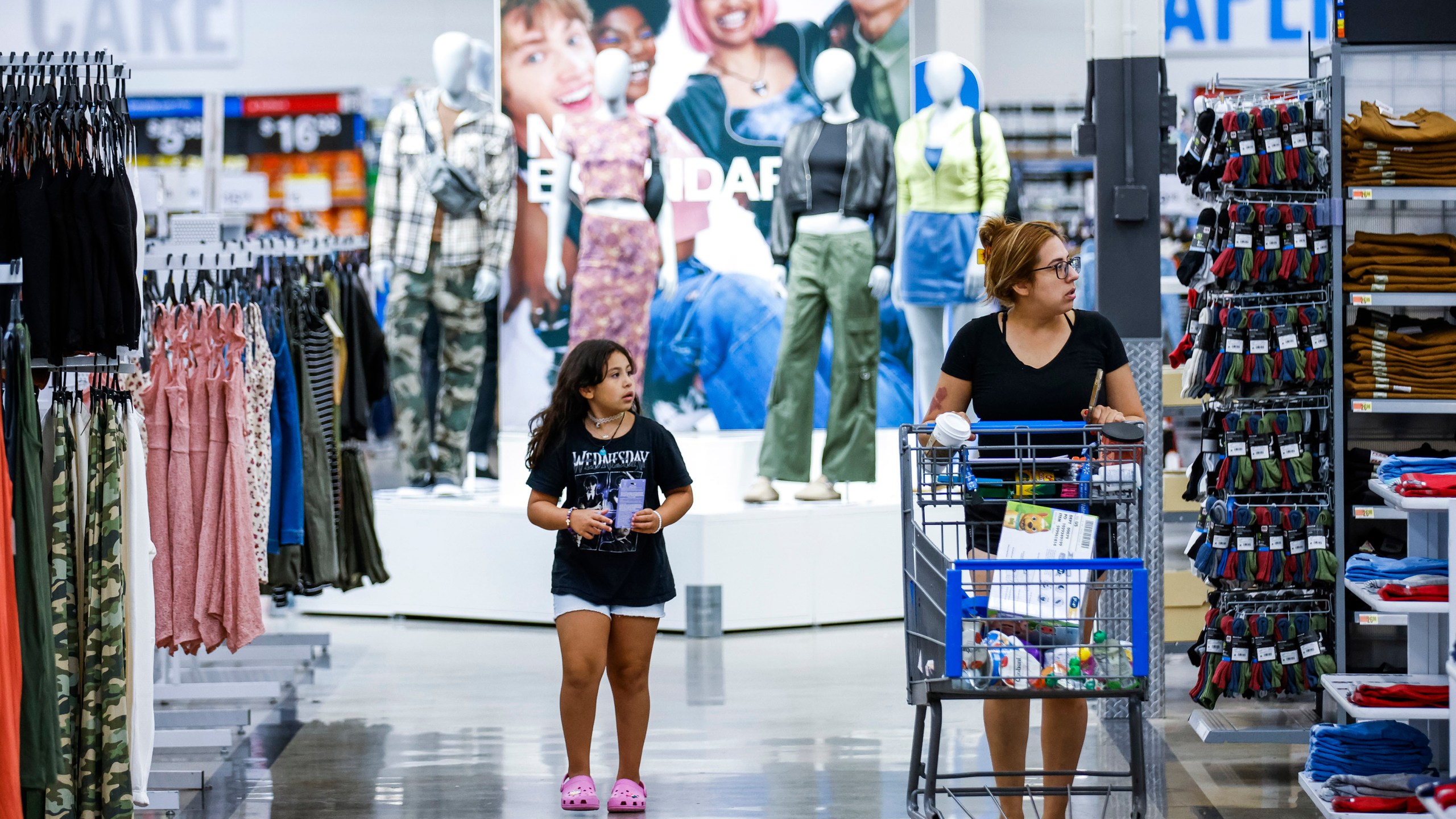 Shoppers pass clothing from Walmart's No Boundaries brand at a Walmart Superstore in Secaucus, New Jersey, Thursday, July 11, 2024. Walmart relaunched No Boundaries, its 30-year-old brand for teenagers and young adults, earlier this month with a new 130-piece fall collection. (AP Photo/Eduardo Munoz Alvarez)