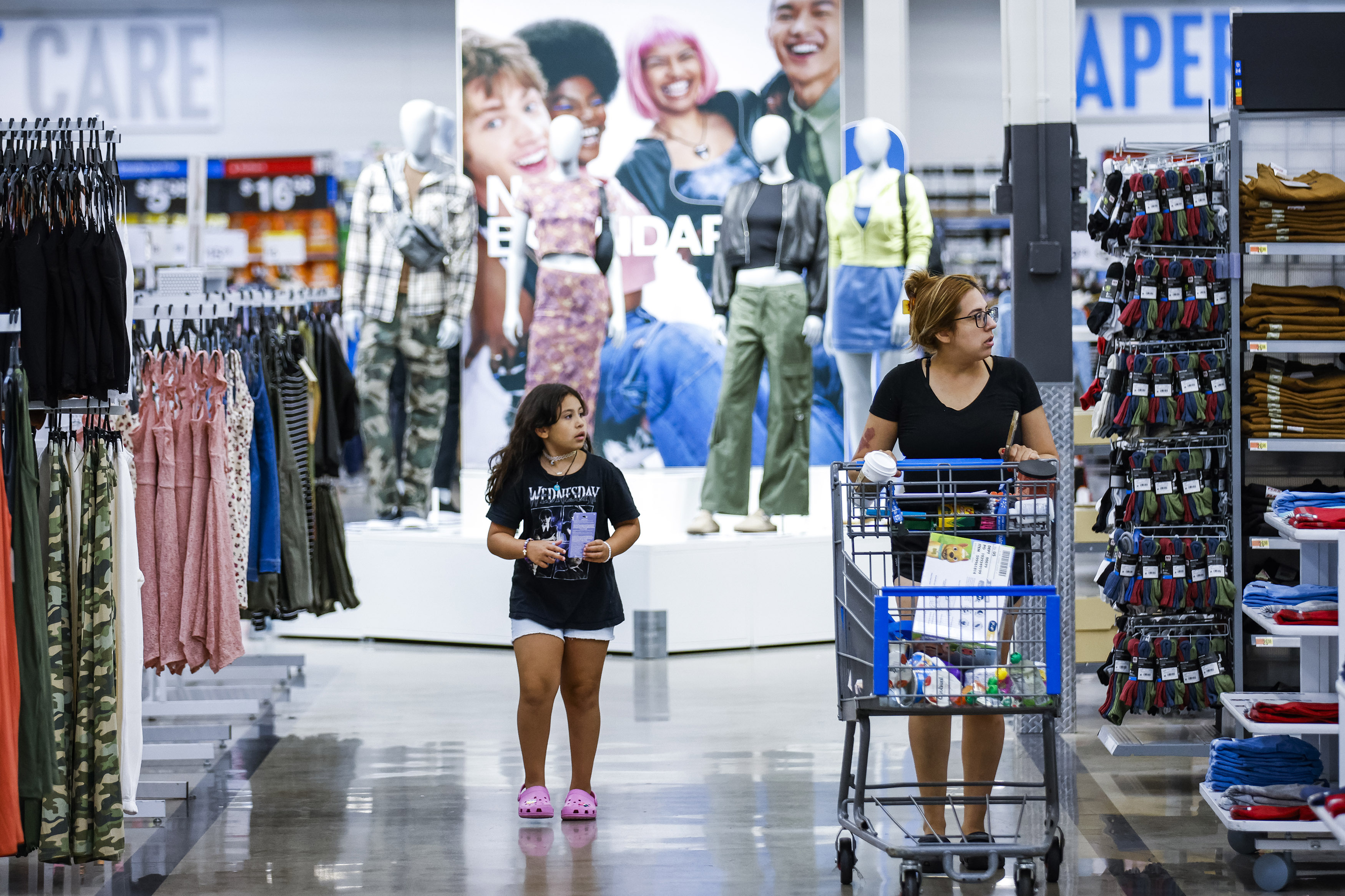 Shoppers pass clothing from Walmart's No Boundaries brand at a Walmart Superstore in Secaucus, New Jersey, Thursday, July 11, 2024. Walmart relaunched No Boundaries, its 30-year-old brand for teenagers and young adults, earlier this month with a new 130-piece fall collection. (AP Photo/Eduardo Munoz Alvarez)