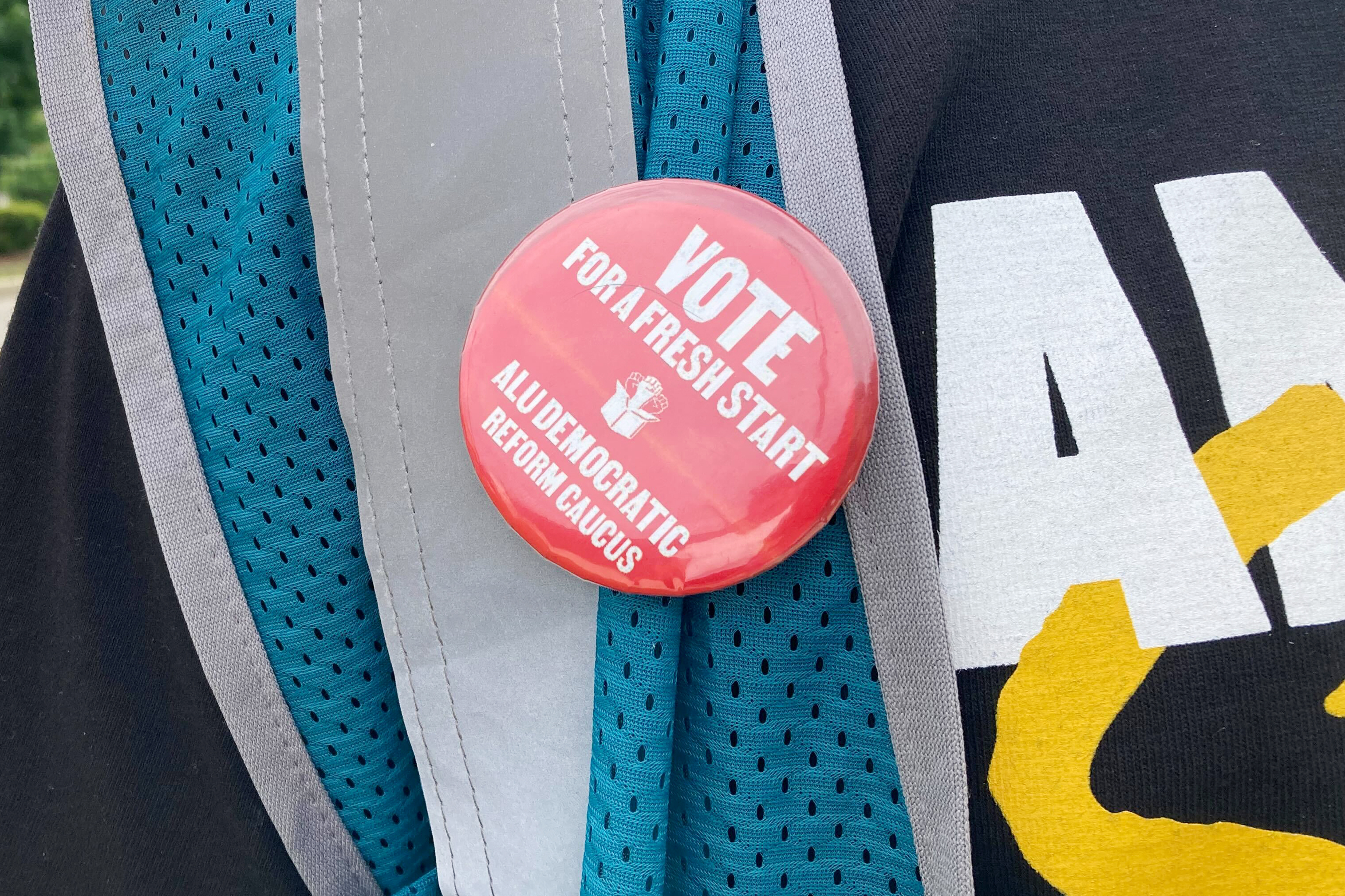 A pin hangs from a vest worn by union organizer and former Amazon worker Connor Spence outside the Amazon warehouse in the borough of Staten Island in New York in Tuesday, June 18, 2024. Workers at Amazon's only unionized warehouse in the U.S. elected new union leaders Tuesday, marking the first major change for the labor group since it established an alliance with the International Brotherhood of Teamsters. Spence is running to be president of the ALU-International Brotherhood of Teamsters Local 1. (AP Photo/Haleluya Hadero)