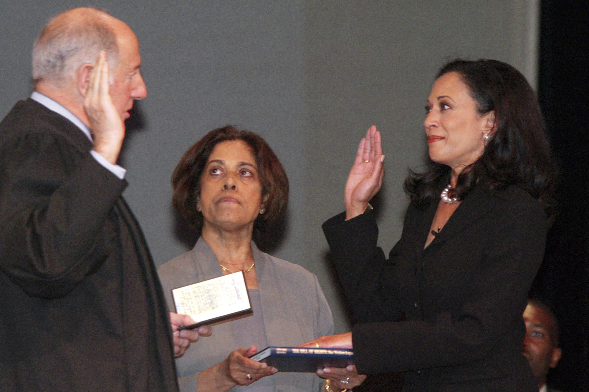 FILE - San Francisco's new district attorney, Kamala Harris, right, with her mother Dr. Shyamala Gopalan holding a copy of The Bill of Rights, receives the oath of office from California Supreme Court Chief Justice Ronald M. George, left, during inauguration ceremonies, Jan. 8, 2004, in San Francisco. (AP Photo/George Nikitin, File)