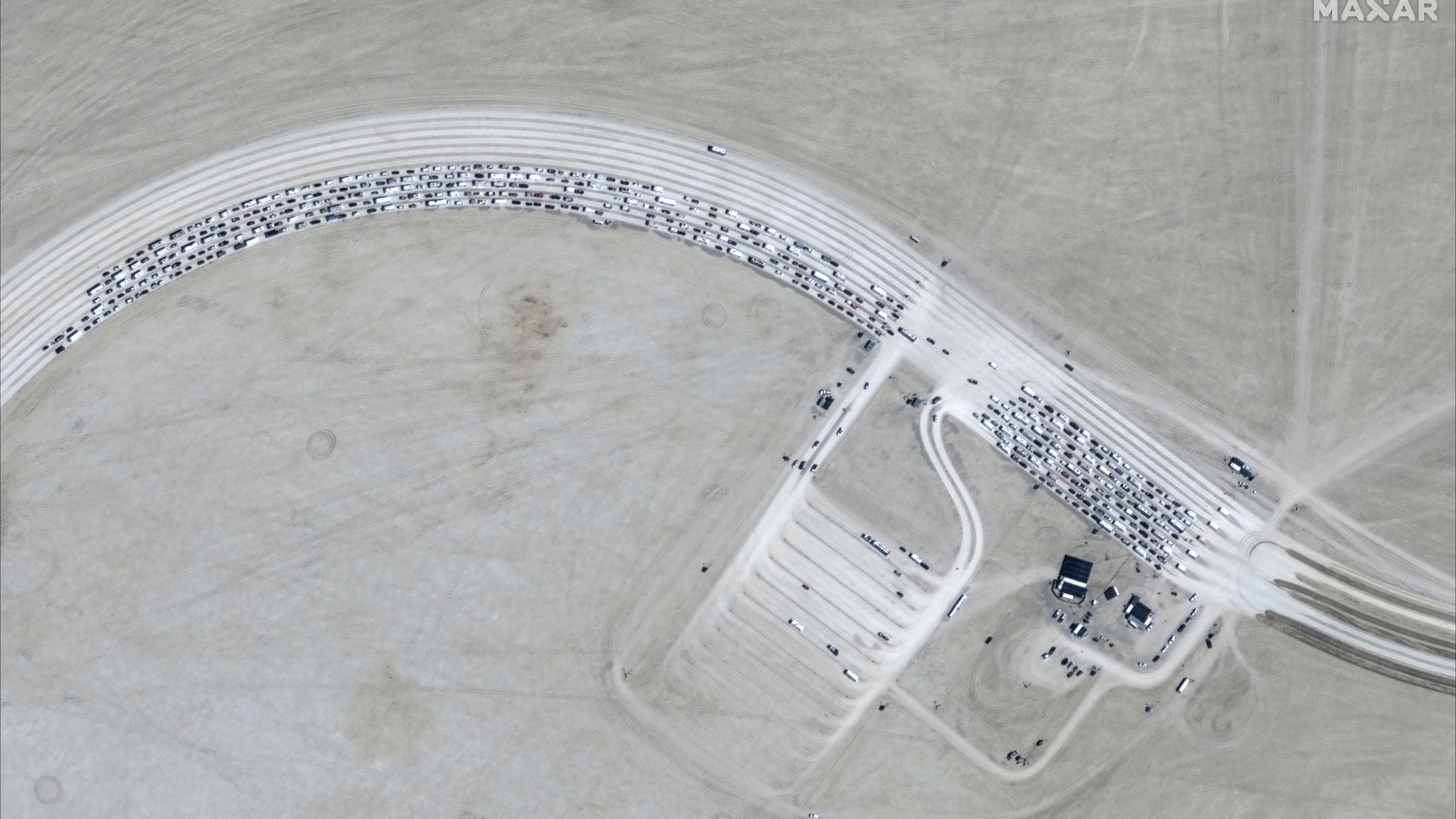 This image released by Maxar Technologies shows vehicles waiting to enter Burning Man 2024 festival, Sunday, Aug. 25, 2024, in Black Rock City, Nev. (Satellite image ©2024 Maxar Technologies via AP)