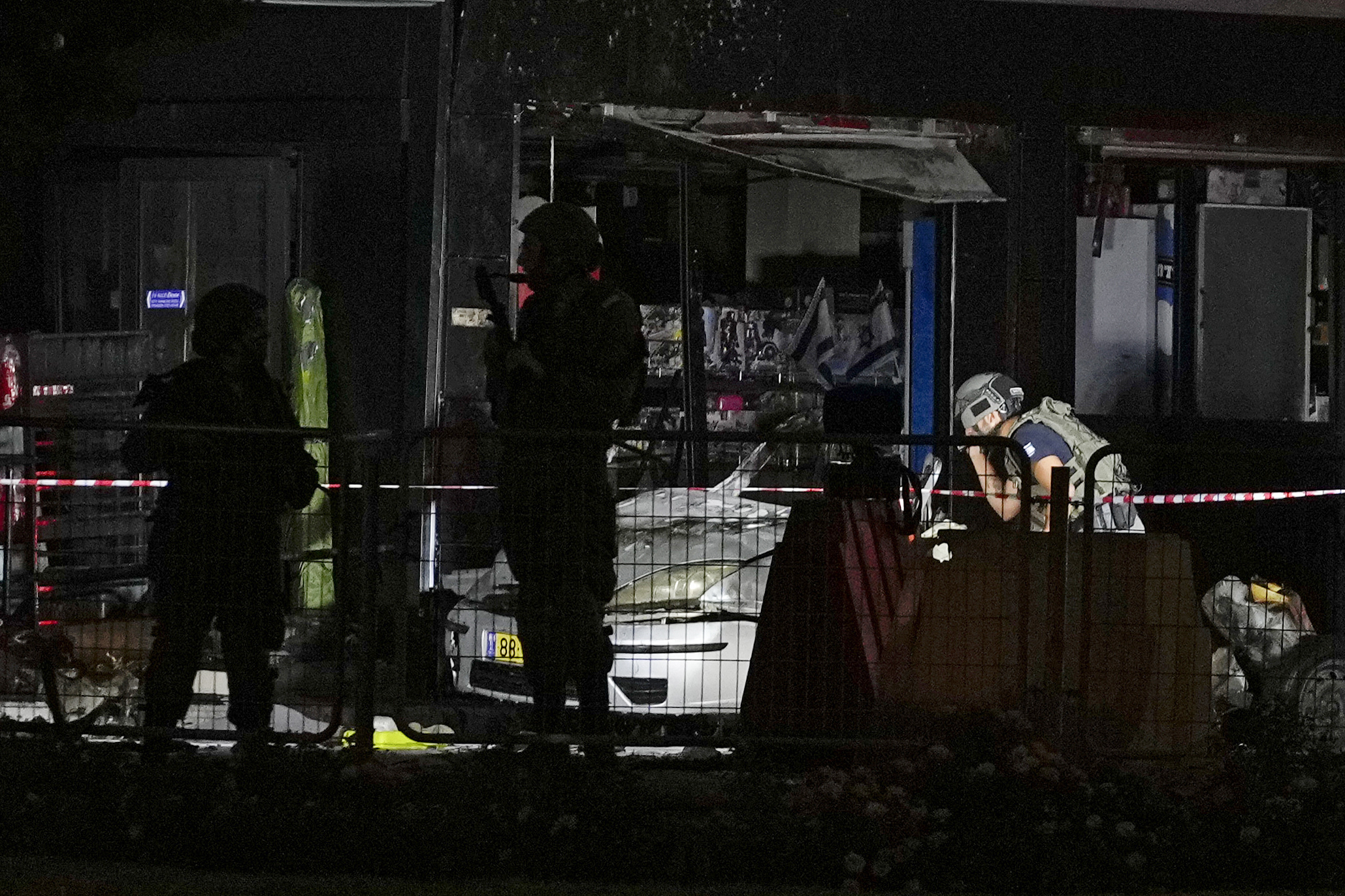 Israeli security forces examine a car after an explosion at a gas station in the West Bank settlement of Gush Etzion, Saturday, Aug. 31, 2024. (AP Photo/Ohad Zwigenberg)