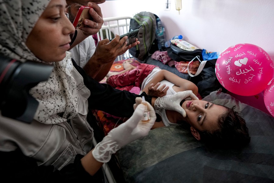 A health worker administers a polio vaccine to a child at a hospital in Khan Younis, Saturday, Aug. 31, 2024. (AP Photo/Abdel Kareem Hana)