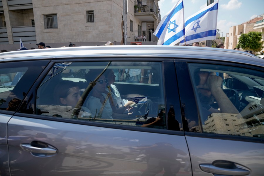 Mourners wave Israeli flags as they accompany the family of Israeli-American hostage Hersh Goldberg-Polin, who was killed in Hamas captivity in the Gaza Strip, on their way to his funeral in Jerusalem, Monday, Sept. 2, 2024. Israel said Sunday it recovered the bodies of six hostages, including Goldberg-Polin's. (AP Photo/Leo Correa)