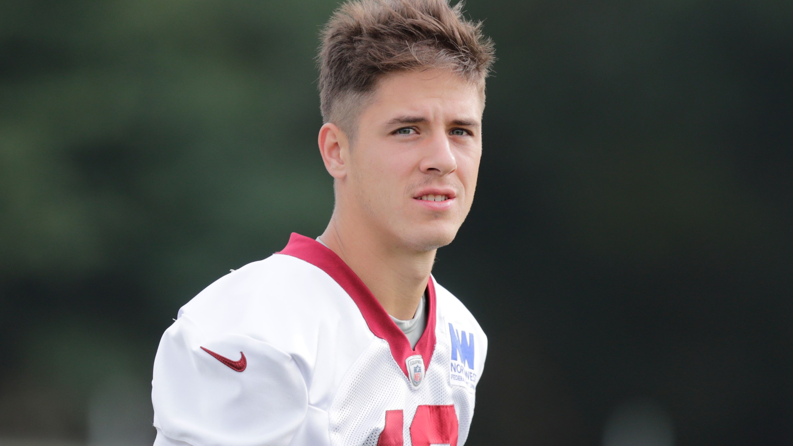 FILE - Washington Commanders wide receiver Luke McCaffrey walks onto the field during an NFL football practice at the team's training facility in Ashburn, Va., on July 26, 2024. Luke McCaffrey this weekend will become the latest member of his family to play in the NFL. (AP Photo/Luis M. Alvarez, File)