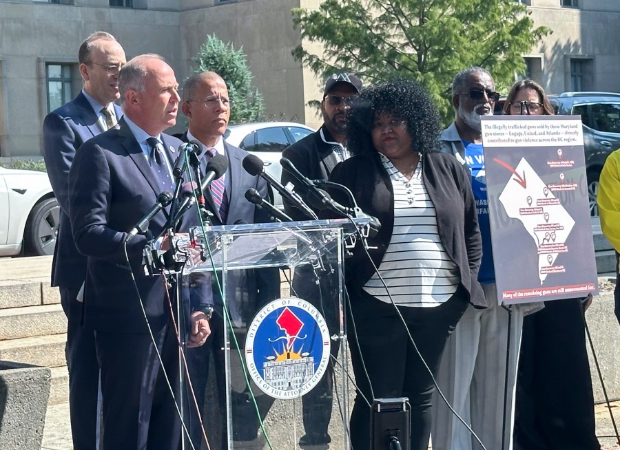 Brian Schwalb, attorney general for the District of Columbia, center left, and Maryland Attorney General Anthony Brown, to his right, speak outside the federal courthouse, Tuesday, Sept. 3, 2024 in Washington. Three gun shops that sold dozens of firearms to a man who trafficked the weapons in and around Washington, D.C., are facing a new lawsuit filed jointly Tuesday by attorneys general for Maryland and the nation’s capital. (AP Photo/Lindsay Whitehurst)