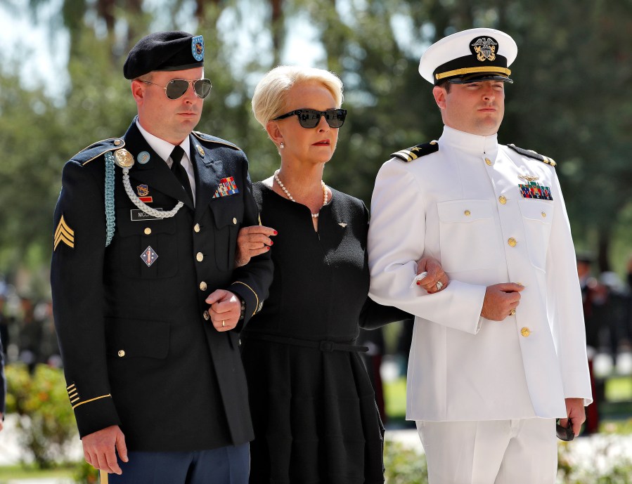 FILE - Cindy McCain, escorted by sons, Jack McCain, right, and Jimmy McCain, follow behind military personal carrying the casket of Sen. John McCain, R-Ariz., into the Capitol rotunda for a memorial service, Aug. 29, 2018, at the Capitol in Phoenix. Jimmy McCain has registered as a Democrat and will vote for Kamala Harris for President in 2024. (AP Photo/Matt York, File)