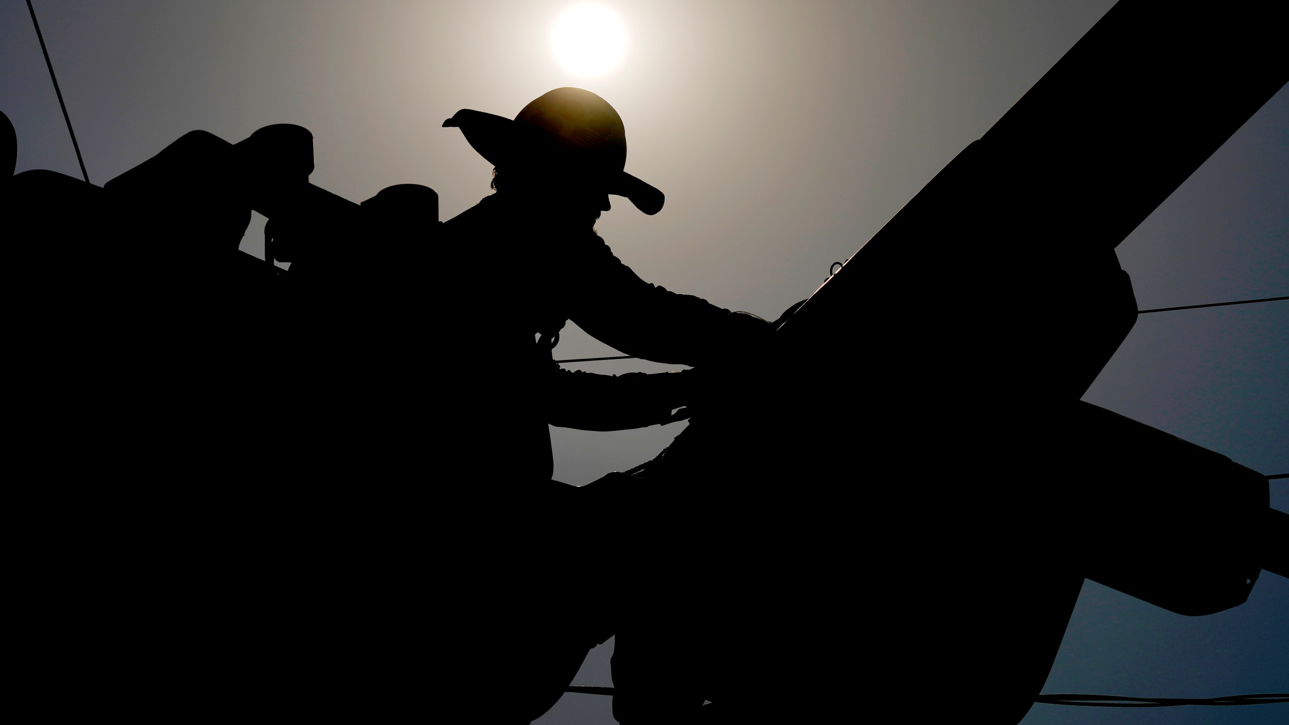 FILE - A linesman works on power lines under the morning sun, July 12, 2024, in Phoenix. (AP Photo/Matt York, File)