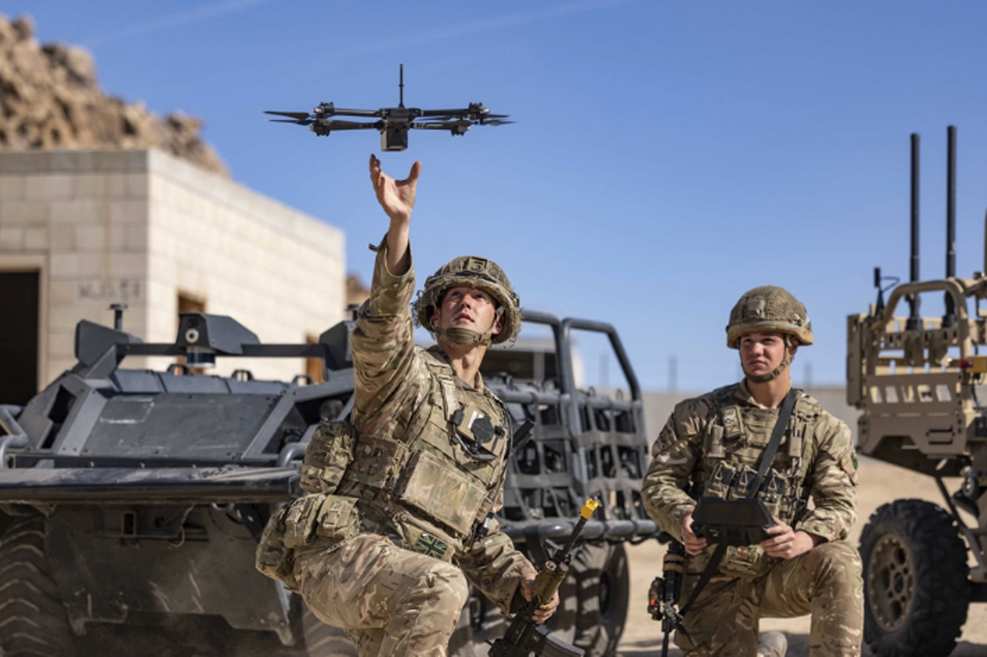 In this photo from the Defense Visual Information Distribution Service, British soldiers launch a drone during Project Convergence exercises at Fort Irwin, Calif., on Nov. 4, 2022. (DVIDS via AP)