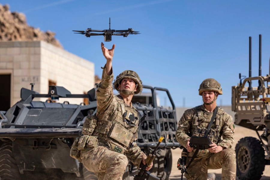 In this photo from the Defense Visual Information Distribution Service, British soldiers launch a drone during Project Convergence exercises at Fort Irwin, Calif., on Nov. 4, 2022. (DVIDS via AP)