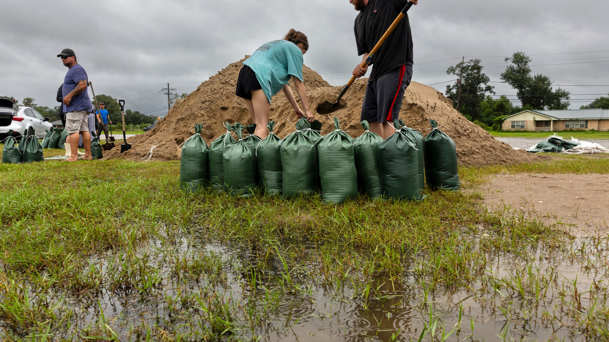 Rainwater accumulates around Nolan and Macie Melancon as they fill up sandbags for their home located a few miles away in Houma, La., as the region gets ready for the arrival of Hurricane Francine on Tuesday, Sept. 10, 2024. (Chris Granger /The Times-Picayune/The New Orleans Advocate via AP)