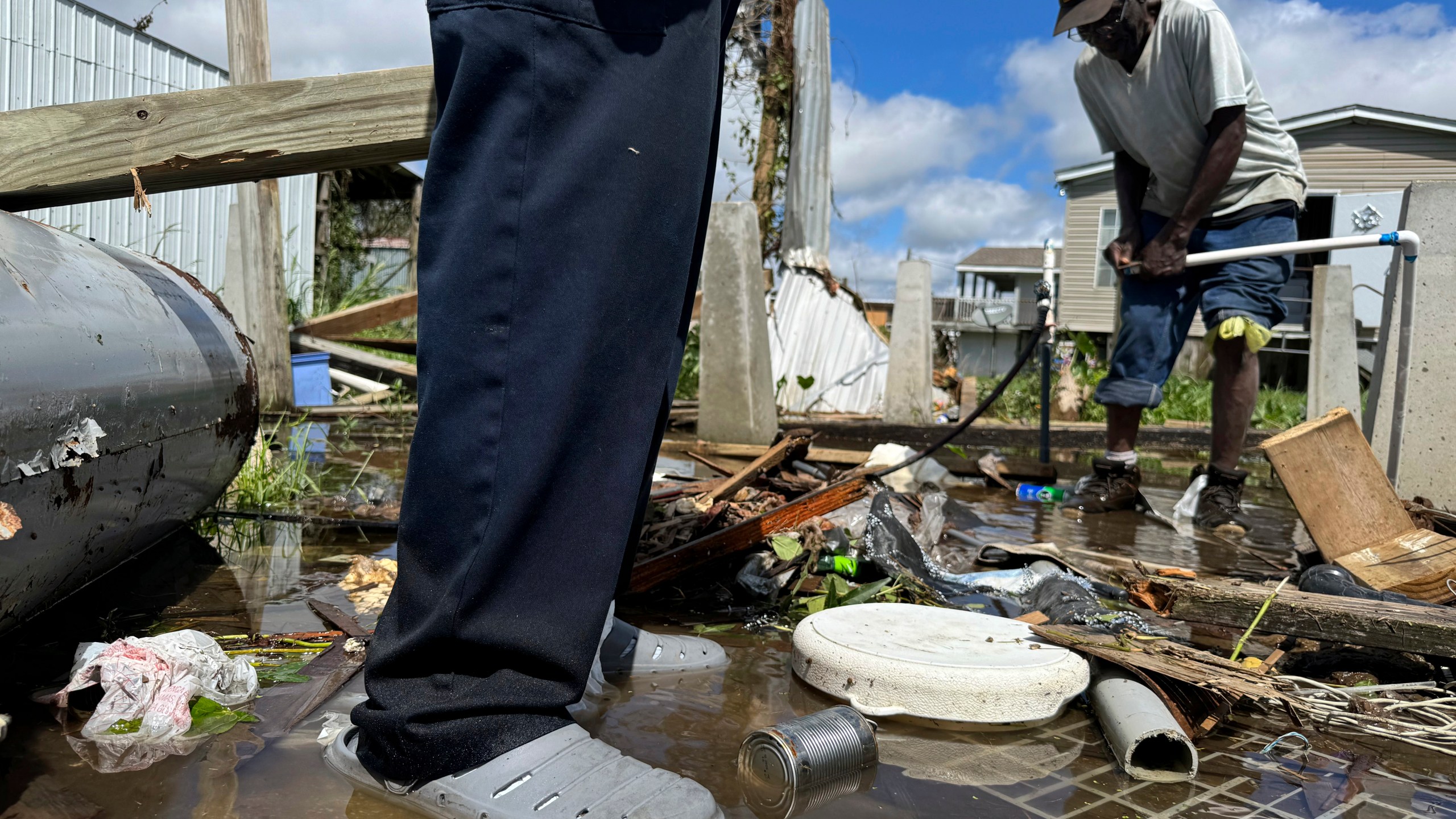 Brothers Wilson Garner, 73, left, and Carter Caldwell, 69, try to fix a broken water pipe, Thursday, Sept. 12, 2024, in Ashland, La., in the aftermath of Hurricane Francine. (AP Photo/Jack Brook)