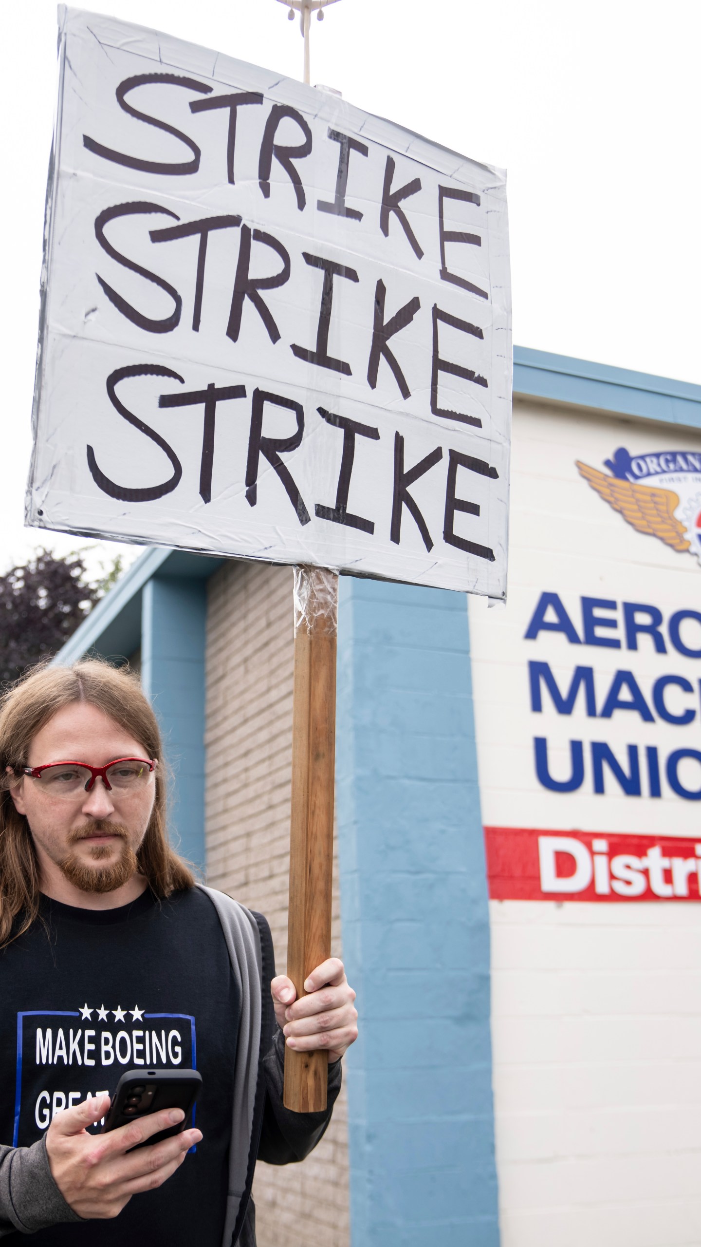 An International Aerospace Machinists union member holds a sign encouraging a strike as fellow union members negotiate a contract offer with airplane maker Boeing, on Thursday, Sept. 12, 2024, in Renton, Wash. (AP Photo/Stephen Brashear)