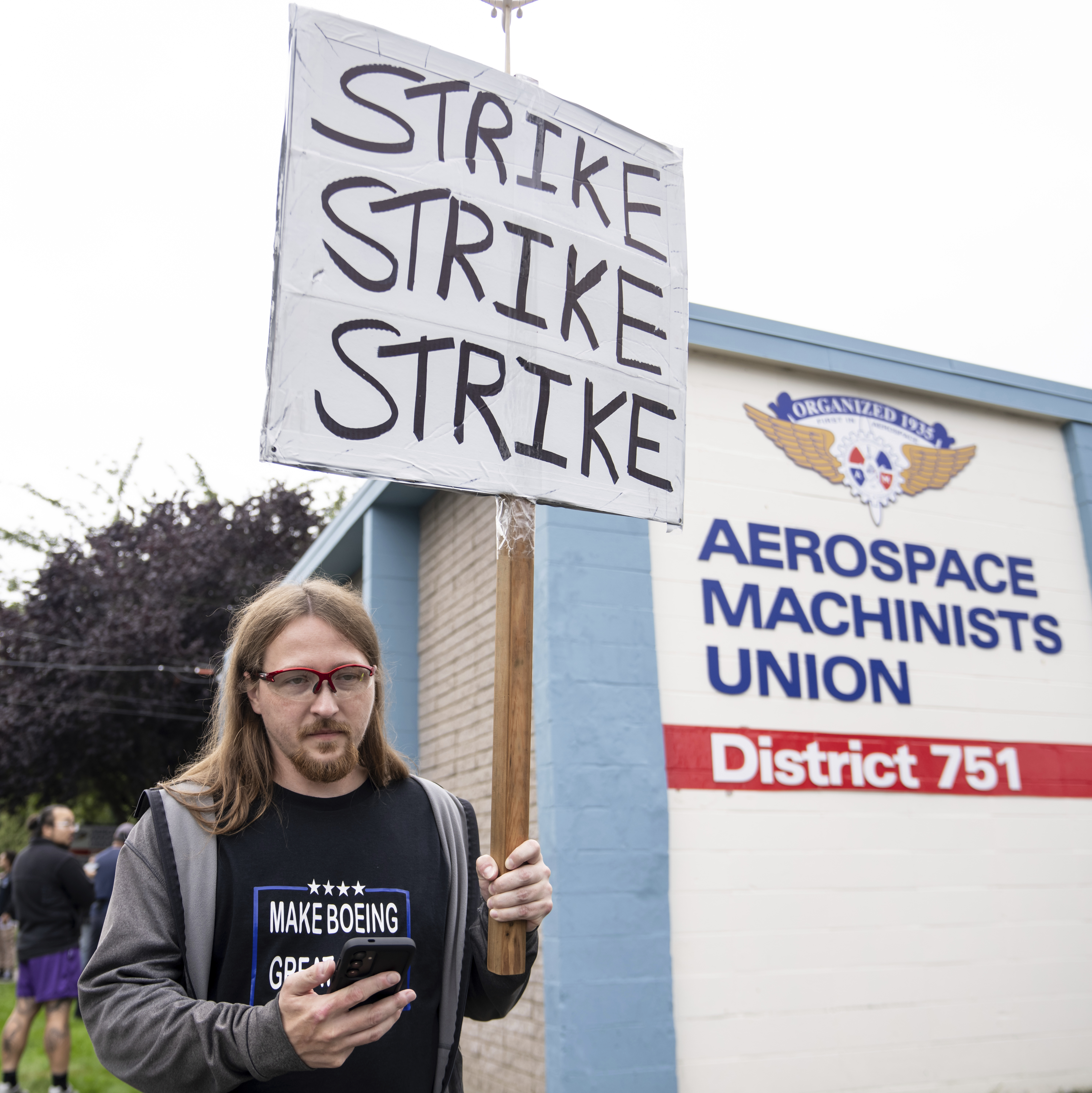 An International Aerospace Machinists union member holds a sign encouraging a strike as fellow union members negotiate a contract offer with airplane maker Boeing, on Thursday, Sept. 12, 2024, in Renton, Wash. (AP Photo/Stephen Brashear)