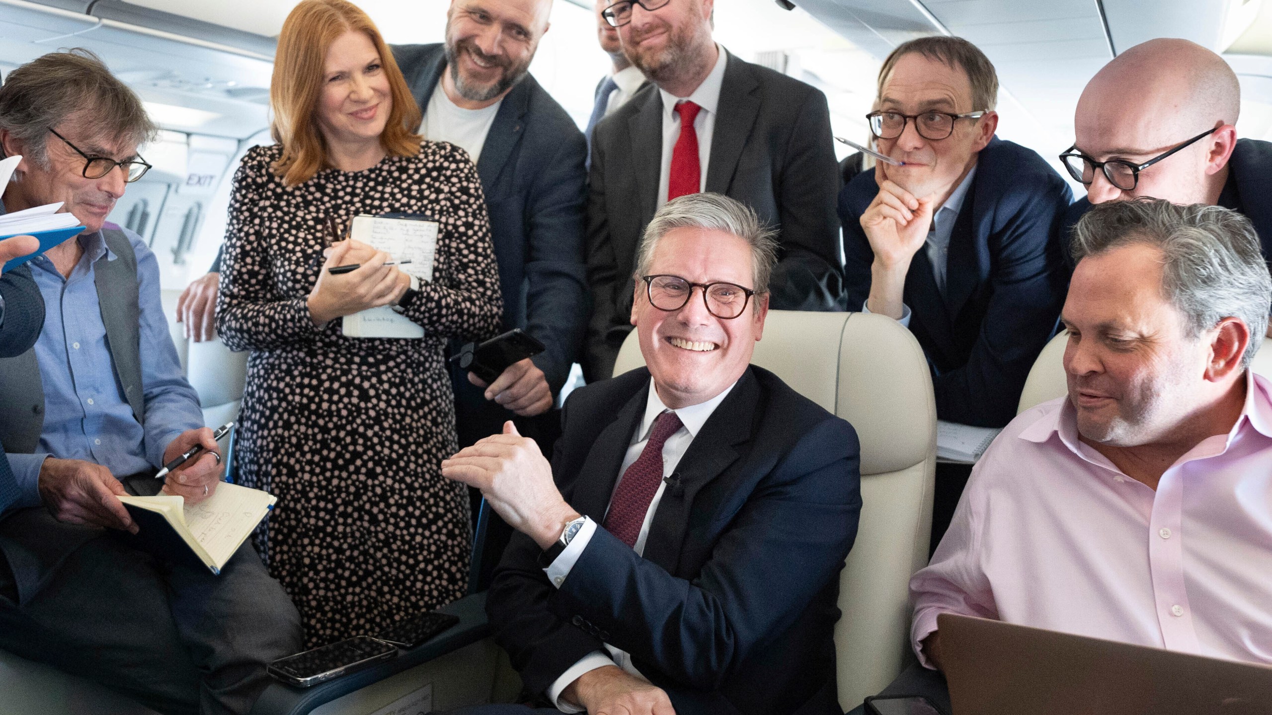 Britain's Prime Minister Keir Starmer, center, talks to the media on board his plane as he flies to Washington DC., Thursday Sept. 12, 2024. (Stefan Rousseau/Pool via AP)