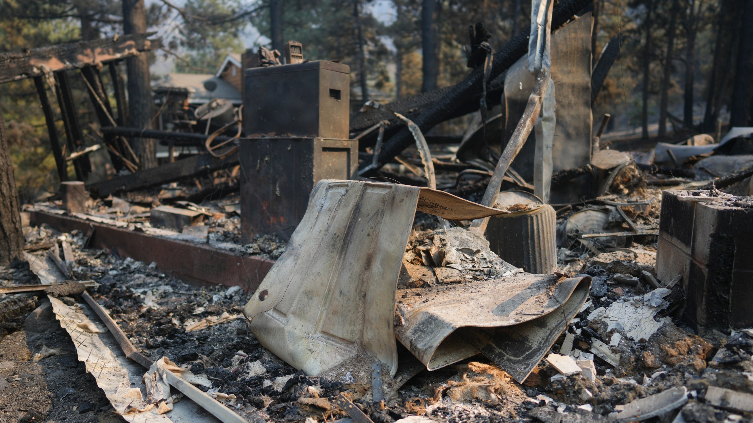 A fire-ravaged property is seen after the Bridge Fire swept through, Thursday, Sept. 12, 2024, in Wrightwood, Calif. (AP Photo/Eric Thayer)