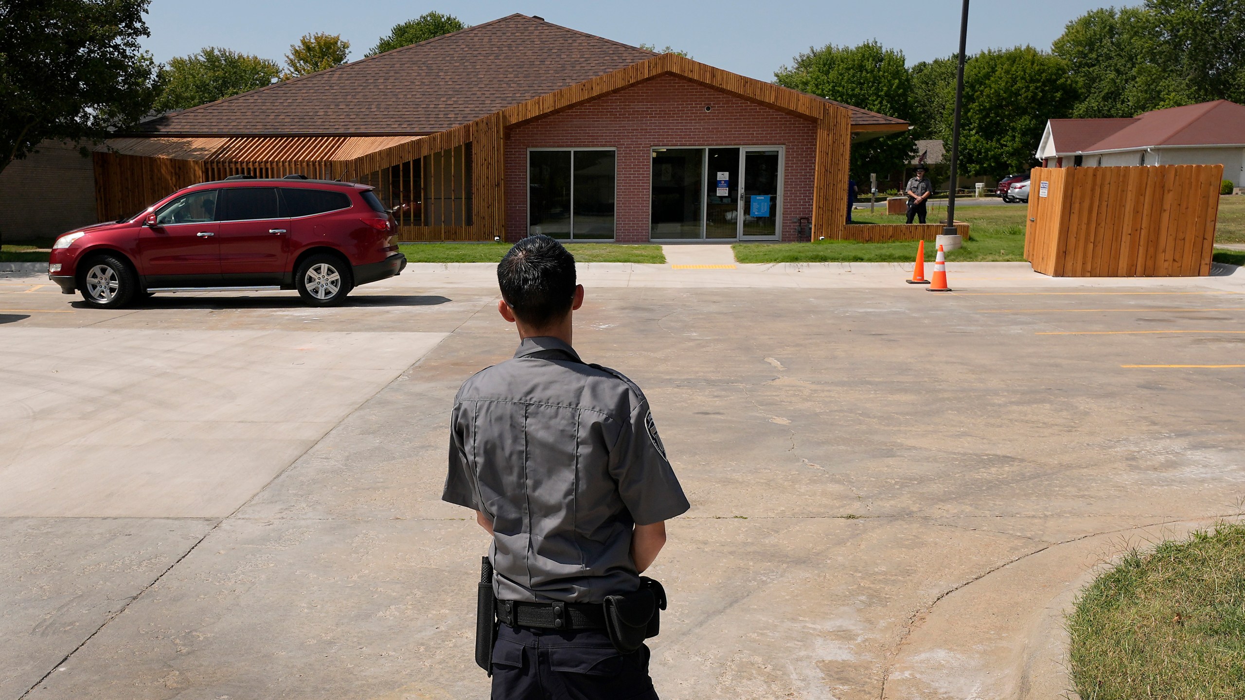 Security personnel stand outside a recently opened Planned Parenthood clinic, Tuesday, Sept. 10, 2024, in Pittsburg, Kan., that is serving patients from Kansas as well as nearby Missouri, Oklahoma, Arkansas, Texas, and other states. (AP Photo/Charlie Riedel)