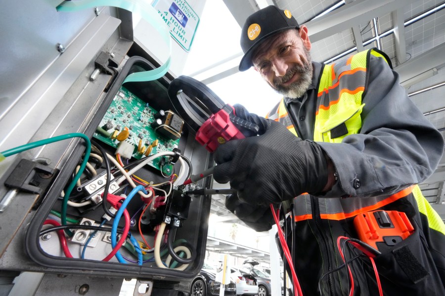 ChargerHelp! technician Pat Gomez checks for power before resetting an electric vehicle charger at La Kretz Innovation Campus in Los Angeles on Thursday, Jan. 25, 2024. (AP Photo/Damian Dovarganes)