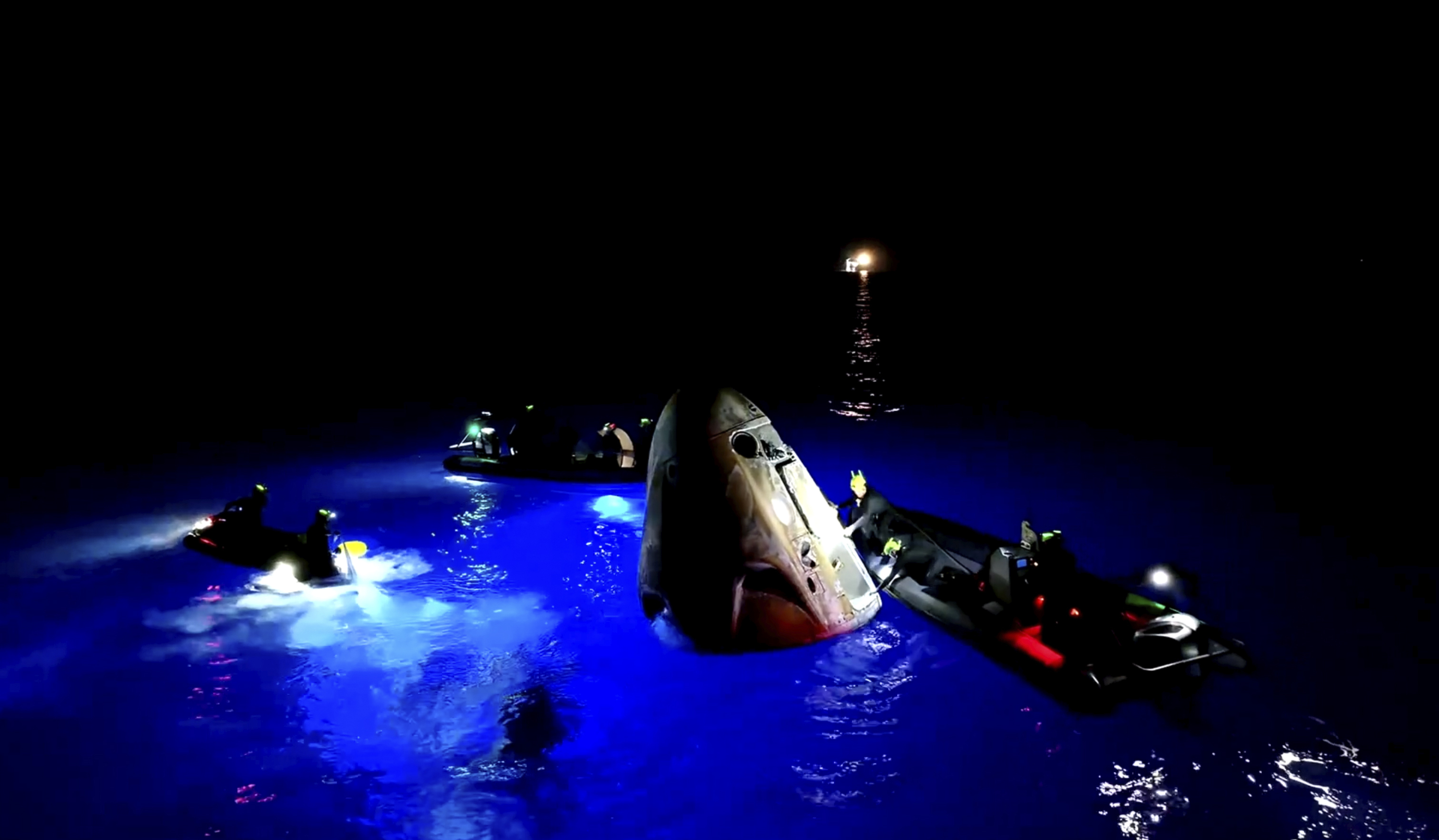 This image made from SpaceX video shows its capsule, center, carrying tech entrepreneur Jared Isaacman with his crew after it reached the Gulf of Mexico near Florida's Dry Tortugas early Sunday, Sept. 15, 2024. (SpaceX via AP)