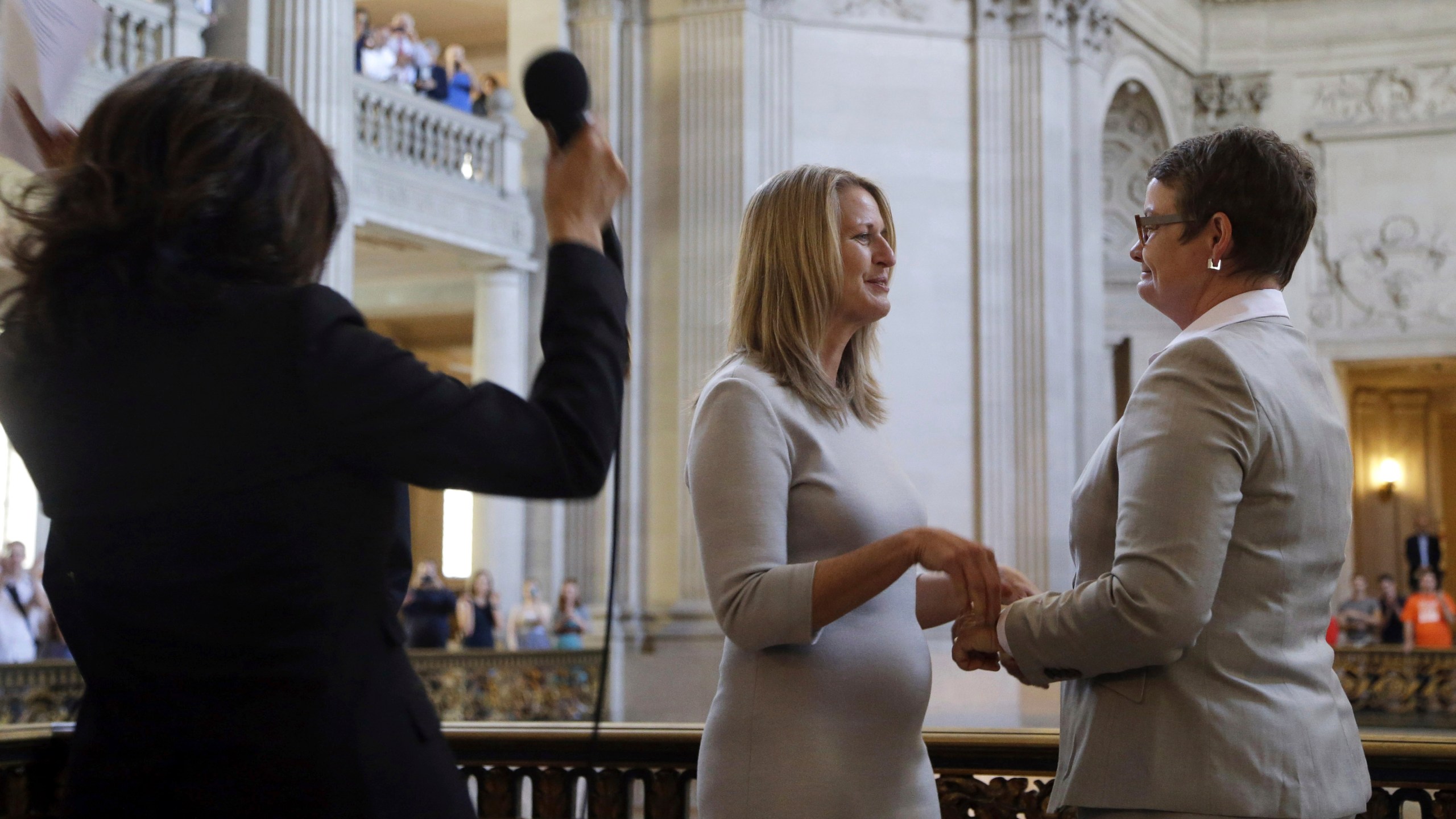 FILE - California Attorney General Kamala Harris, left, reacts after conducting the wedding vows of Kris Perry, from right, and Sandy Stier, at City Hall in San Francisco, June 28, 2013. (AP Photo/Marcio Jose Sanchez, File)