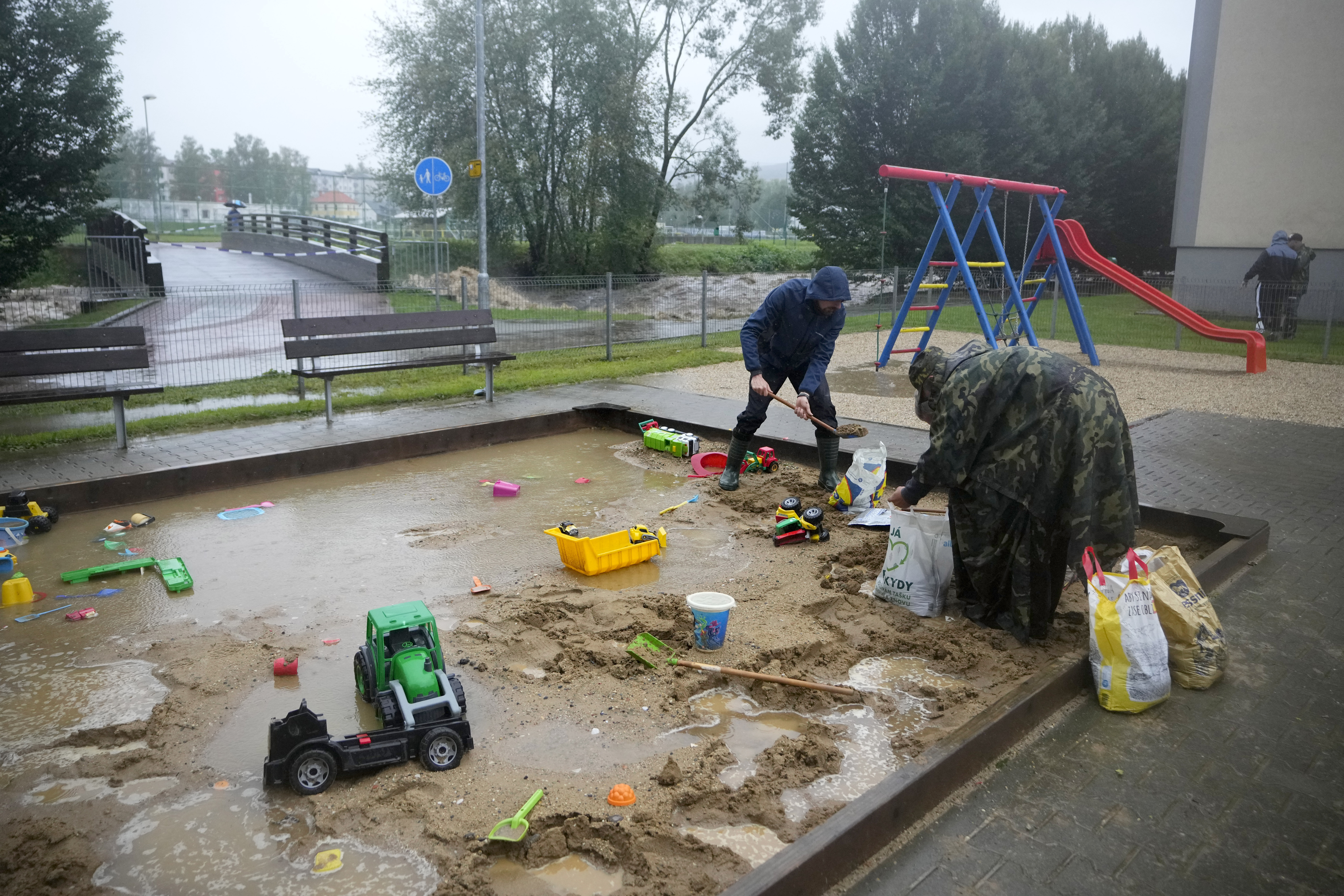 Residents fill sand bags to protect their houses during floods in Jesenik, Czech Republic, Sunday, Sept. 15, 2024. (AP Photo/Petr David Josek)