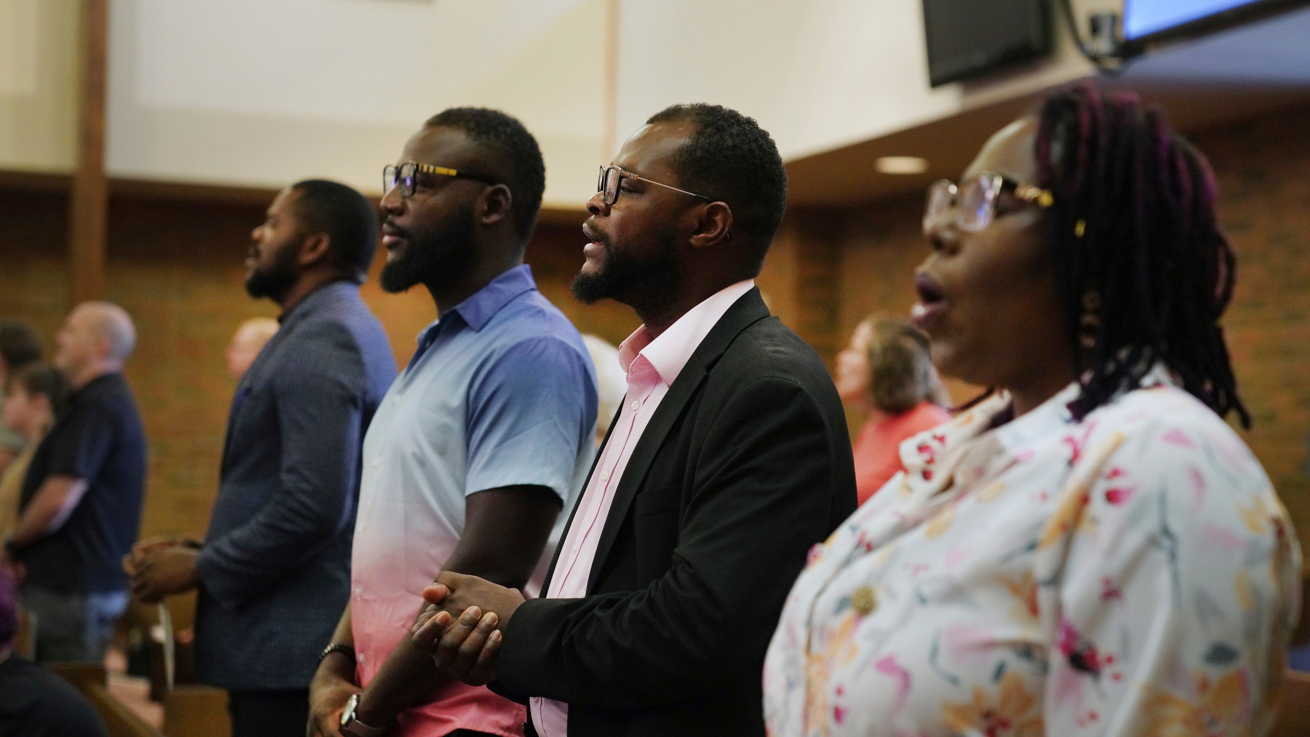 Members of the Haitian community in Springfield, Ohio, from left, Lindsay Aime, James Fleurijean, Viles Dorsainvil, and Rose-Thamar Joseph, stand for worship at Central Christian Church, on Sunday, Sept. 15, 2024. (AP Photo/Jessie Wardarski)