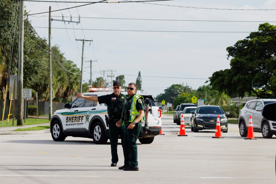 Police officers direct traffic near Trump International Golf Club after the apparent assassination attempt of Republican presidential nominee former President Donald Trump in West Palm Beach, Fla., Sunday, Sept. 15, 2024. (AP Photo/Terry Renna)