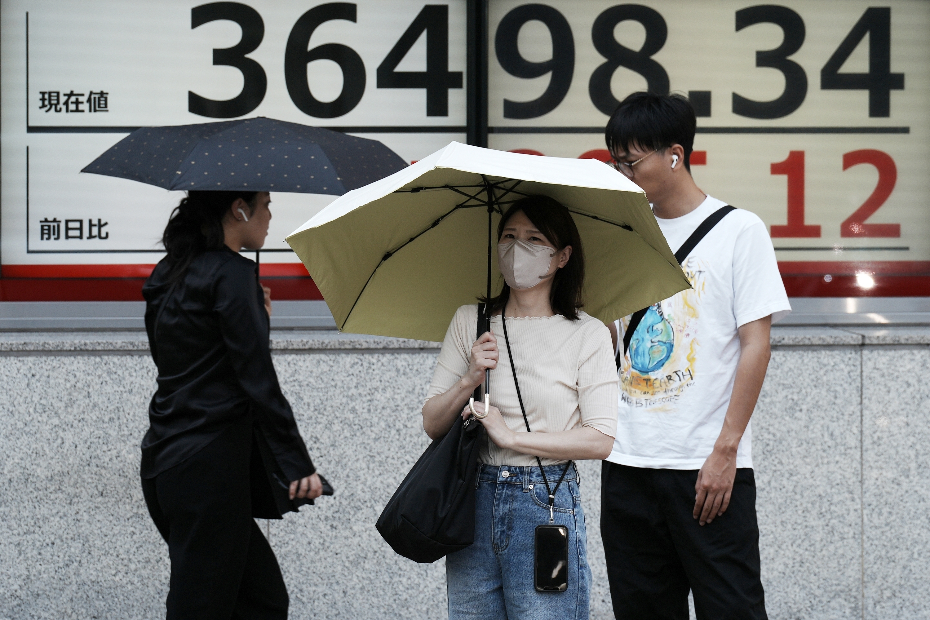 People stand in front of an electronic stock board showing Japan's Nikkei index at a securities firm Wednesday, Sept. 18, 2024, in Tokyo. (AP Photo/Eugene Hoshiko)