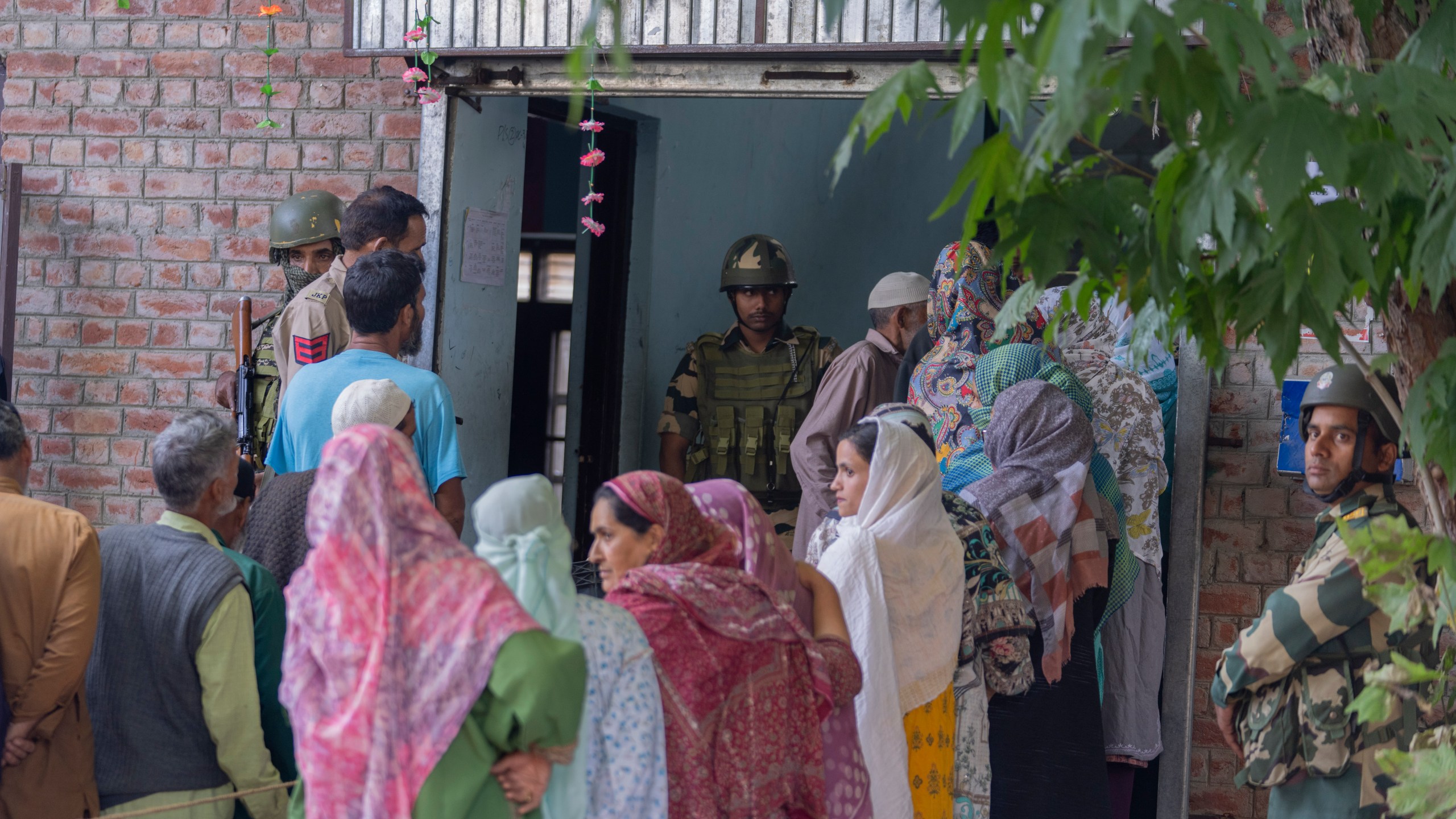 Indian paramilitary soldiers stand guard as people queue up at a polling booth to cast their vote in Naira, south of Srinagar, Indian controlled Kashmir, Wednesday, Sept. 18, 2024. (AP Photo/Dar Yasin)