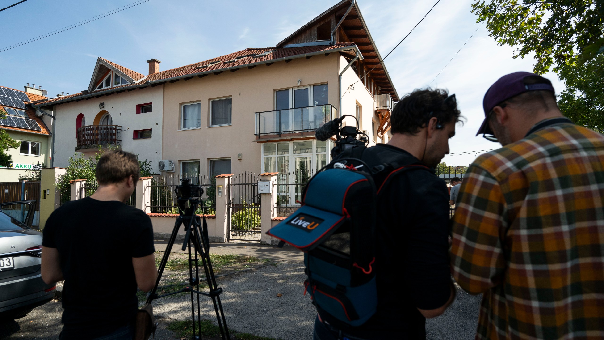 Local media works around a house where a Hungarian company that allegedly manufactured pagers that exploded in Lebanon and Syria, is headquartered in Budapest Wednesday, Sept. 18, 2024. (AP Photo/Denes Erdos)