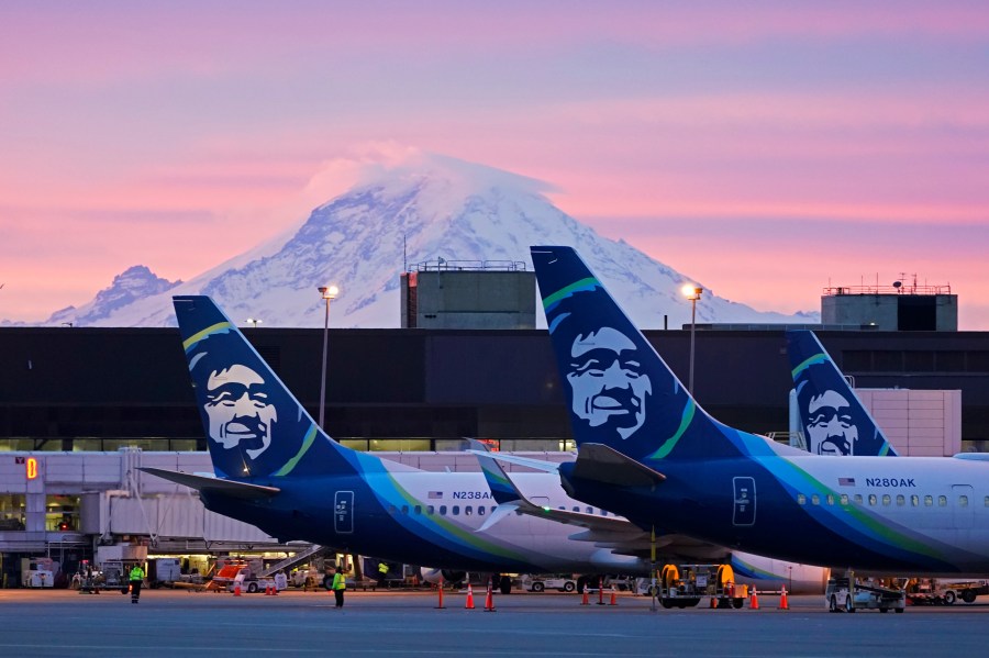 FILE - Alaska Airlines planes are shown parked at gates with Mount Rainier in the background on March 1, 2021, at Seattle-Tacoma International Airport in Seattle. (AP Photo/Ted S. Warren, File)