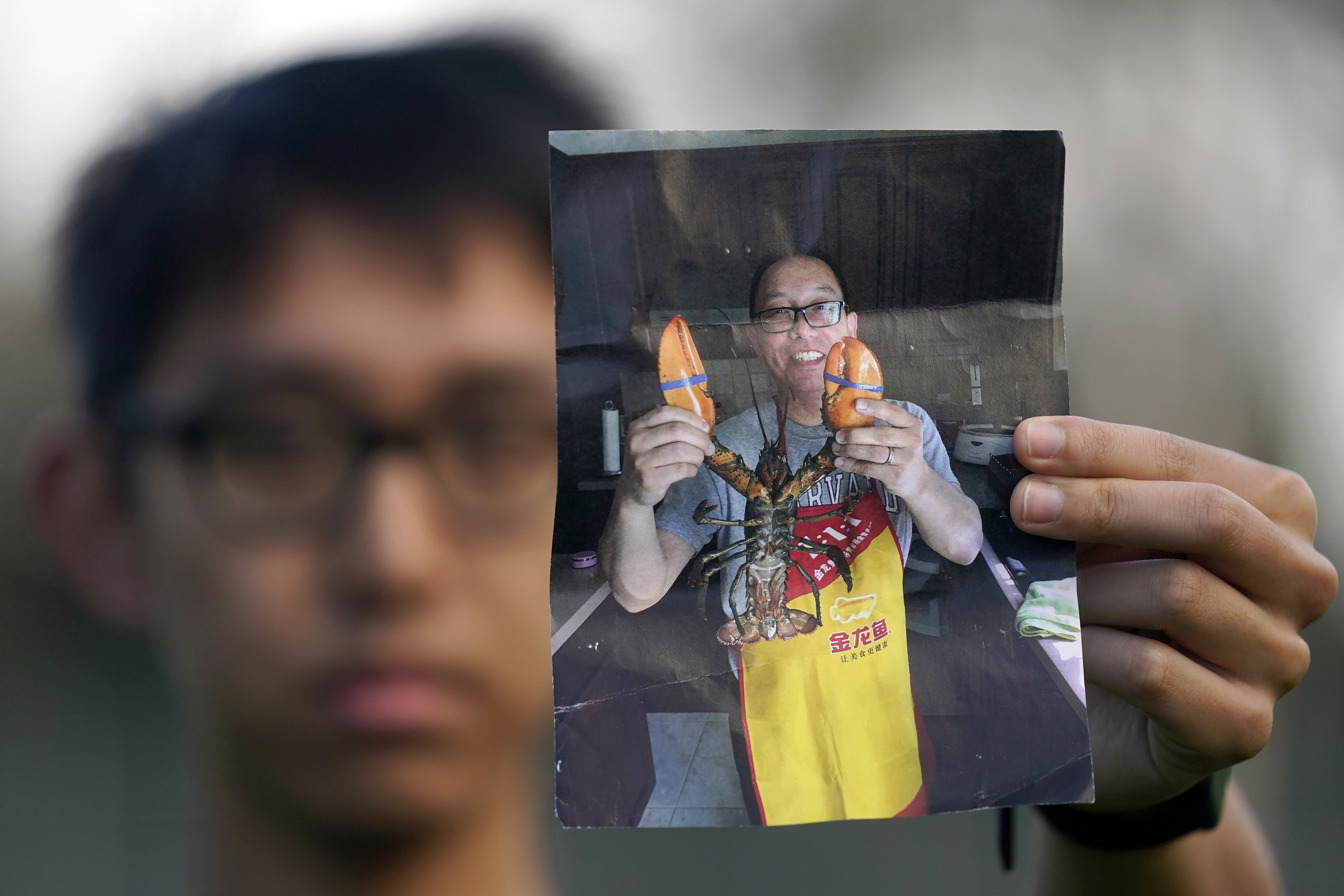 FILE - Harrison Li holds a photo of his father, Kai Li, as he poses for a photo, Jan. 23, 2024, in Palo Alto, Calif. (AP Photo/Jeff Chiu, File)